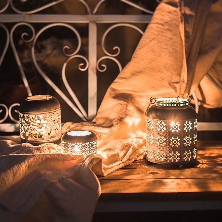 A rustic metal lantern candle holder made of rusted iron, showcasing unique colors and shapes, perfect for home decor.