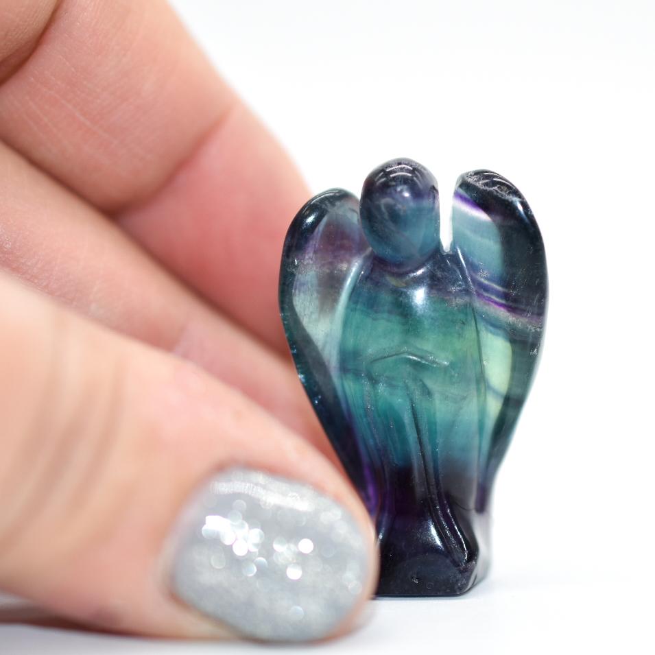 A collection of Mini Angel Carvings made from Angelite, Fluorite, Amethyst, Quartz, and Rose Quartz, showcasing their intricate details and vibrant colors.