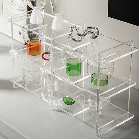 A modern acrylic counter shelf displaying books and decorative items, showcasing its stylish and compact design.