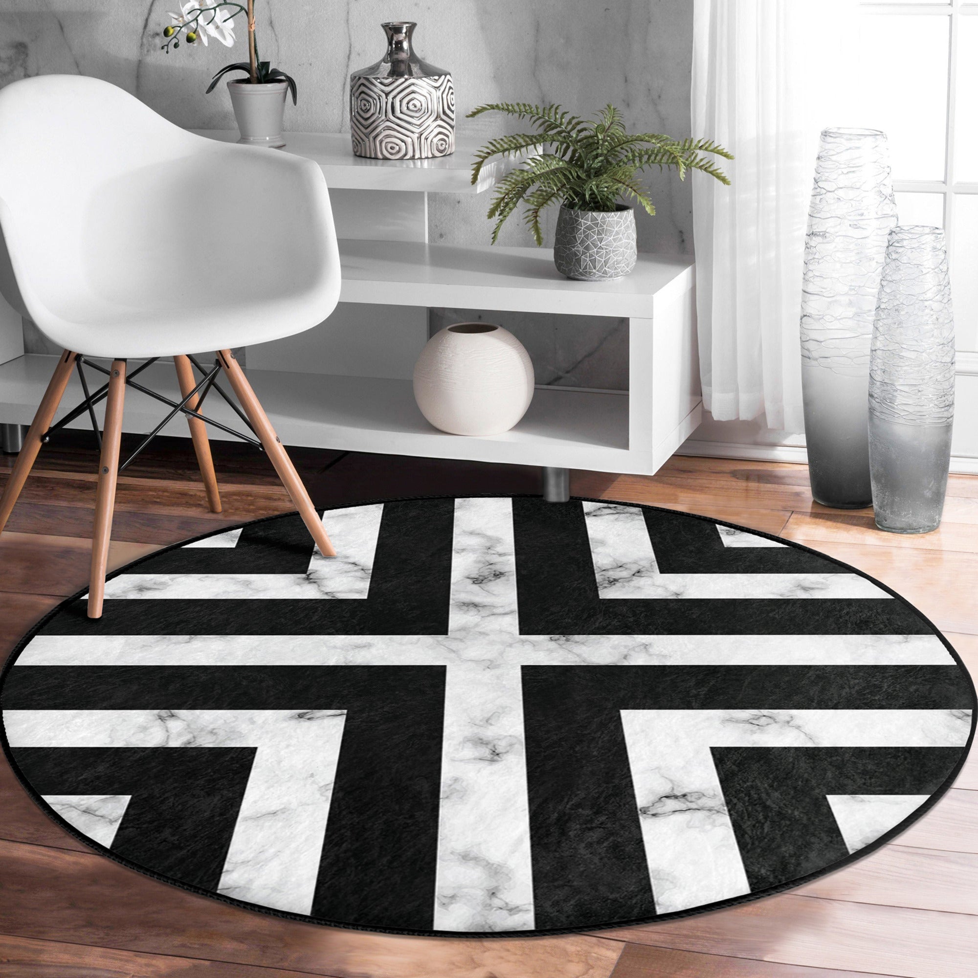 Modern round rug in black and white design, showcasing a soft velvet texture and non-slip backing, perfect for living room decor.