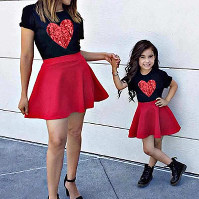 Mom and daughter wearing matching summer heart print T-shirt and skirt set, showcasing a playful and stylish design perfect for family outings.