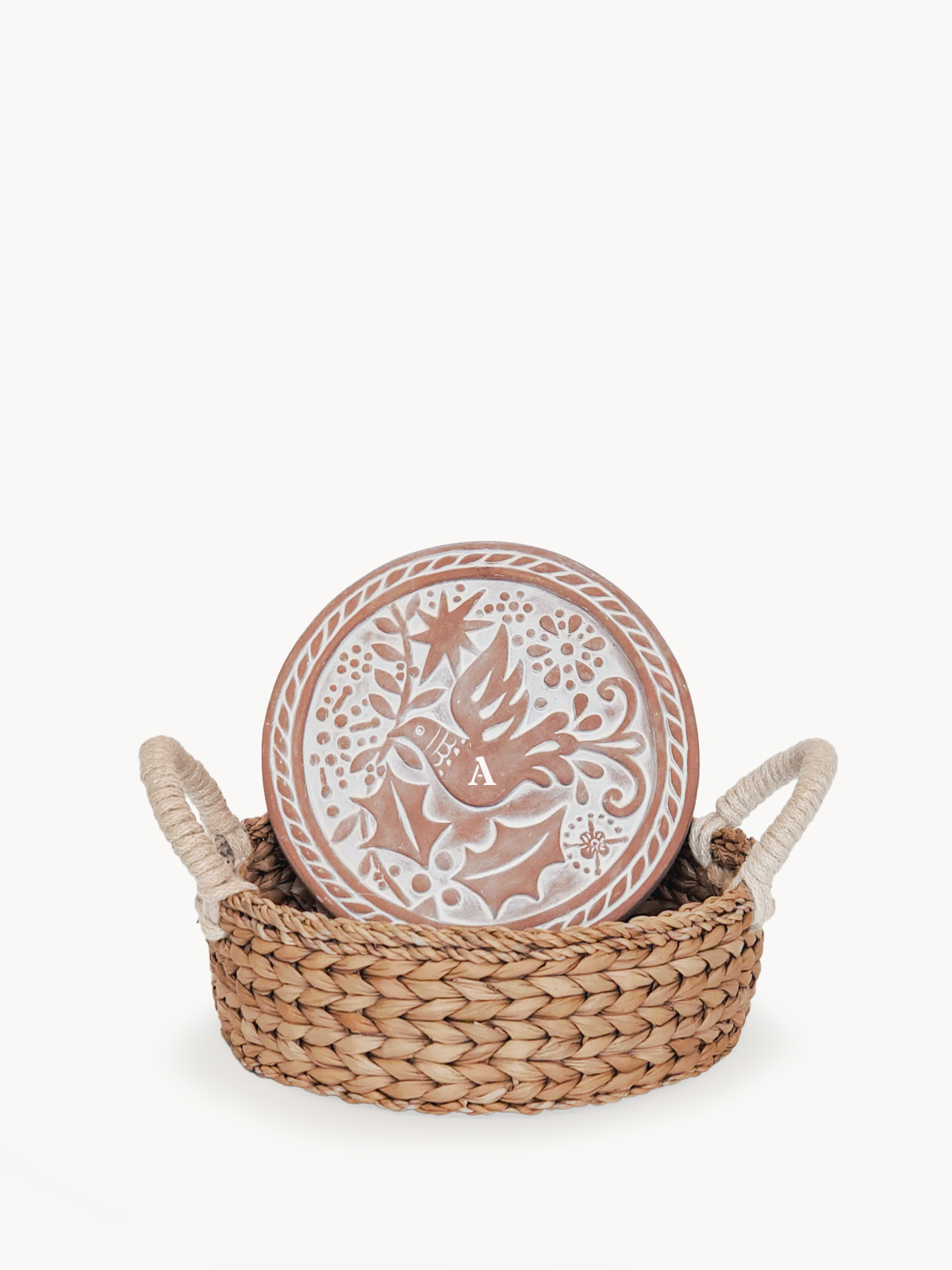 Monogrammed bread warmer and handwoven seagrass basket featuring a bird design, perfect for serving warm bread.