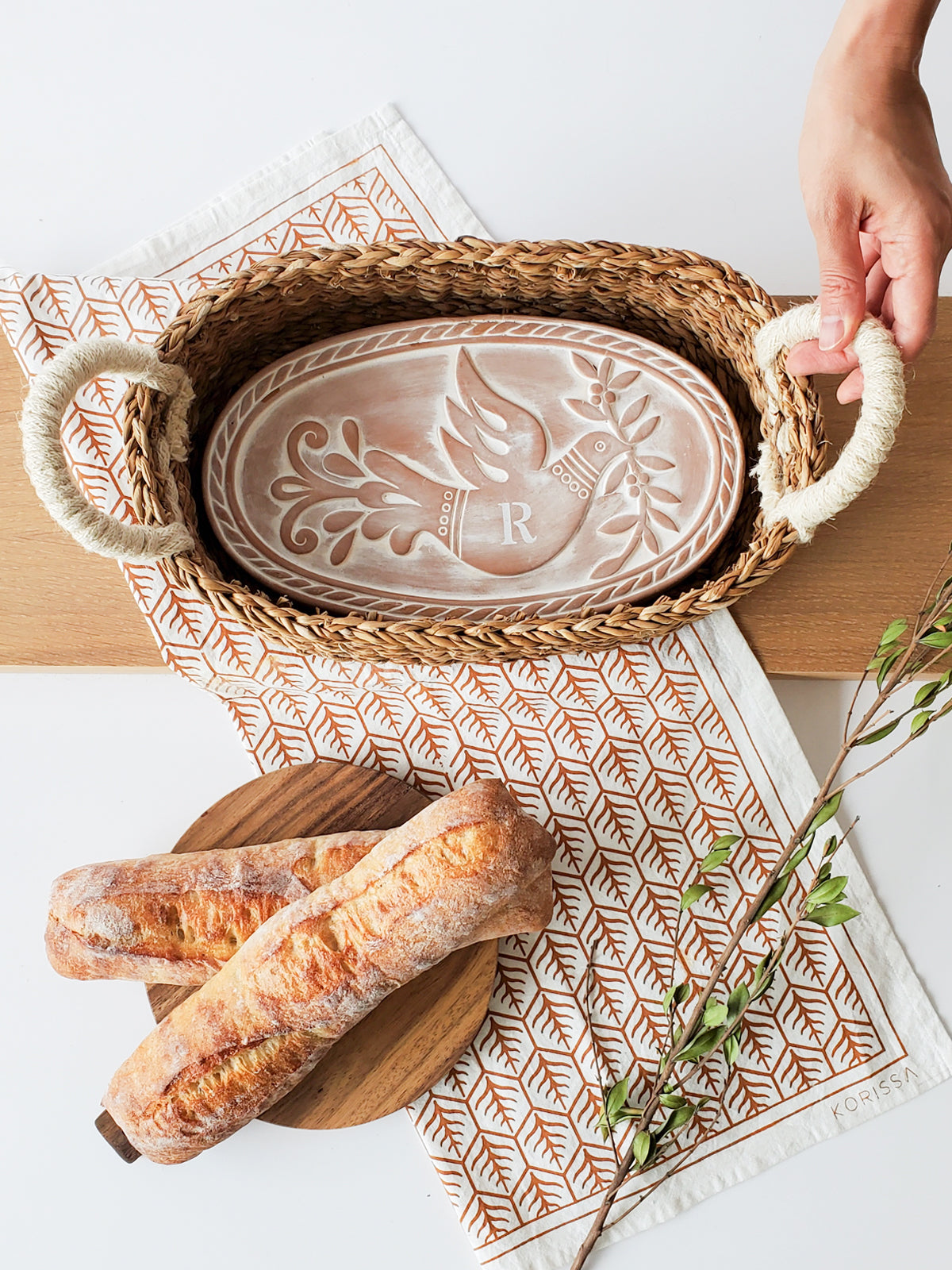 Monogrammed Bread Warmer and Basket Gift Set featuring a bird design, including a terracotta warmer, handwoven seagrass basket, and a cotton tea towel.