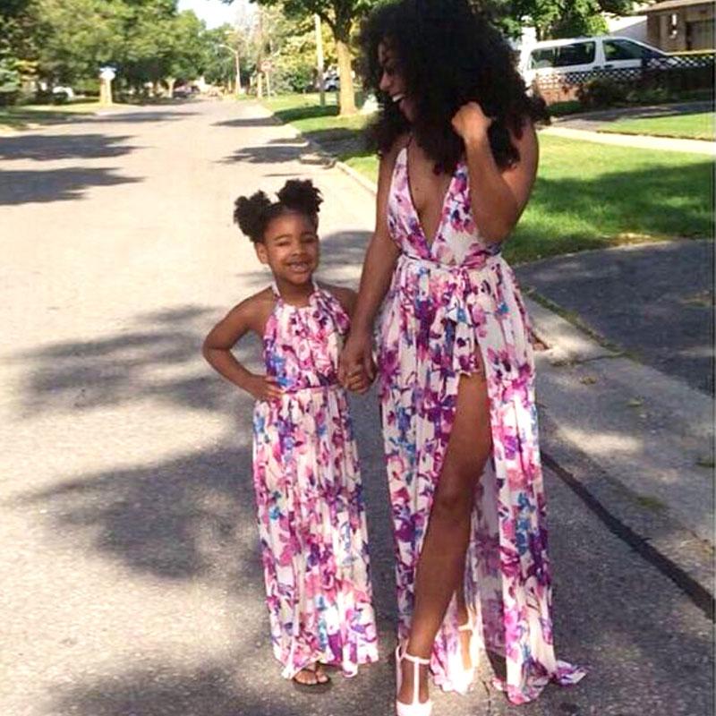 A stylish mother and daughter wearing matching floral print dresses with a V-neck design, perfect for summer outings.