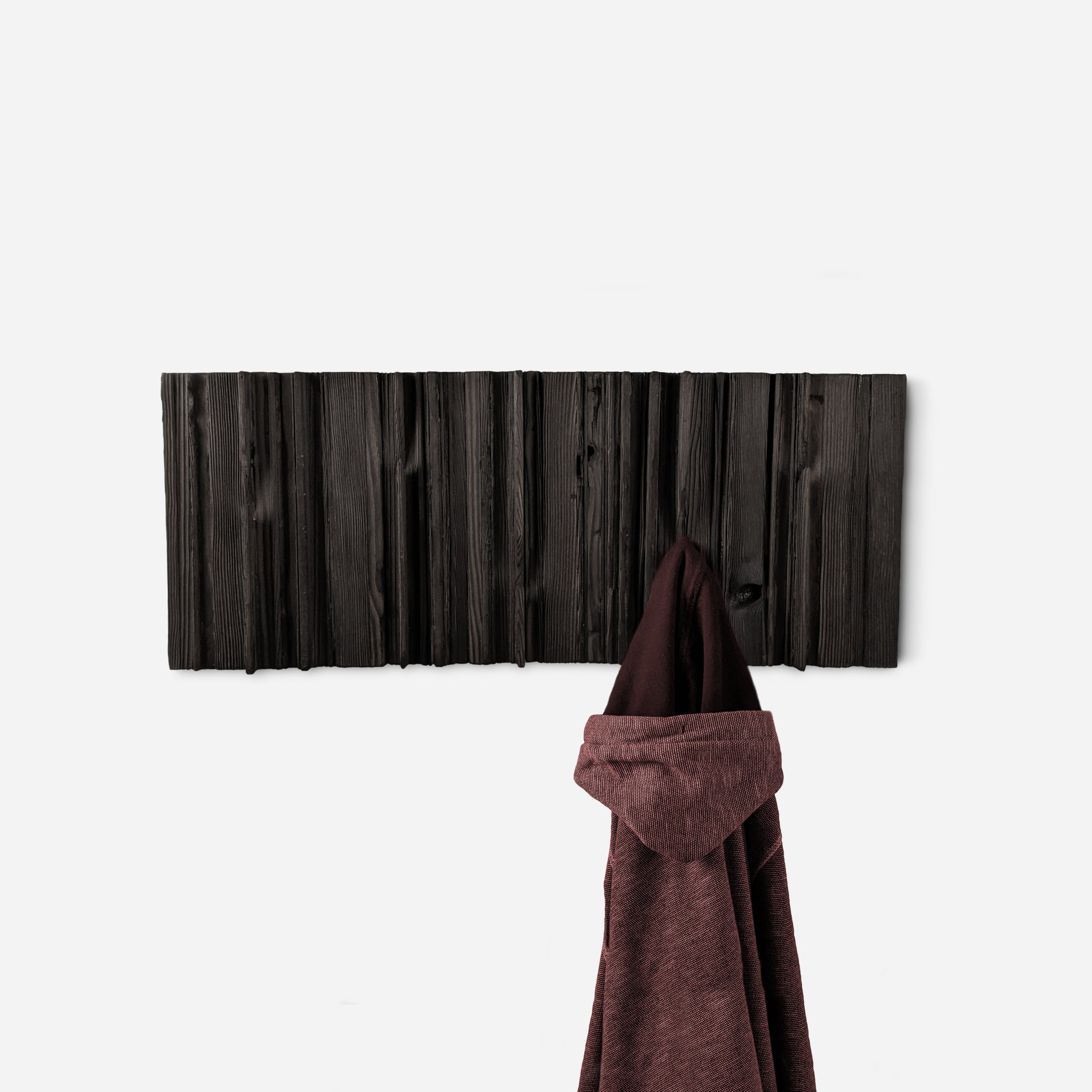 Mr. Hook coat rack featuring unique wood design with brass hooks, showcasing torched black and natural wood finish.