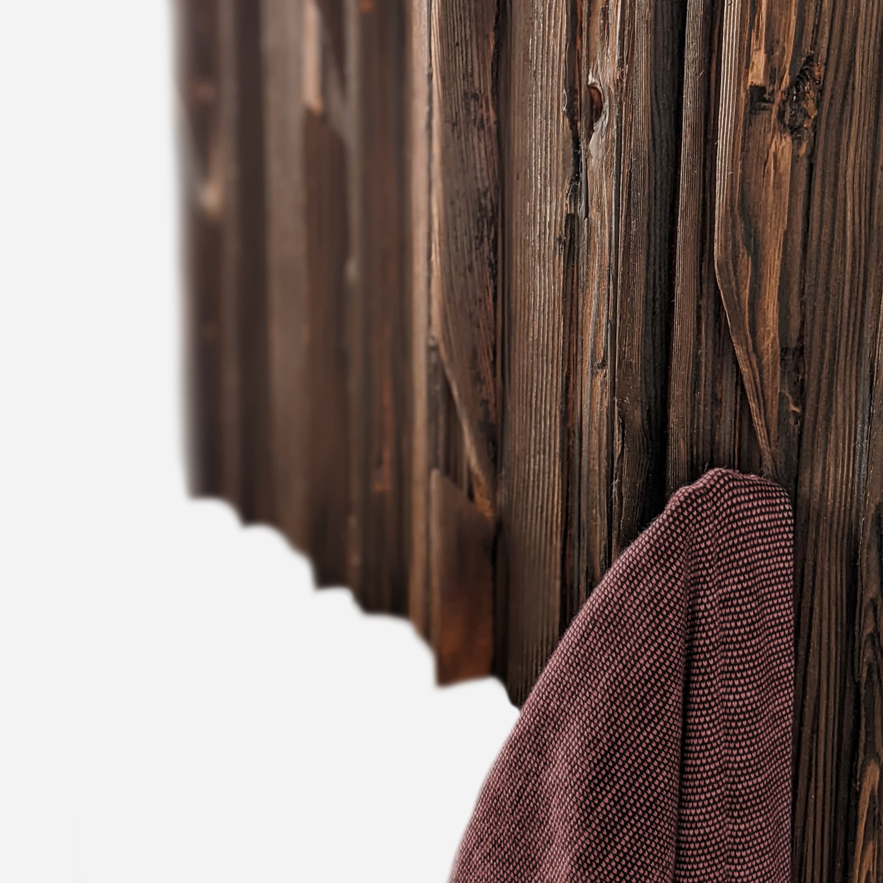 Mr. Hook coat rack featuring unique wood design with brass hooks, showcasing torched black and natural wood finish.