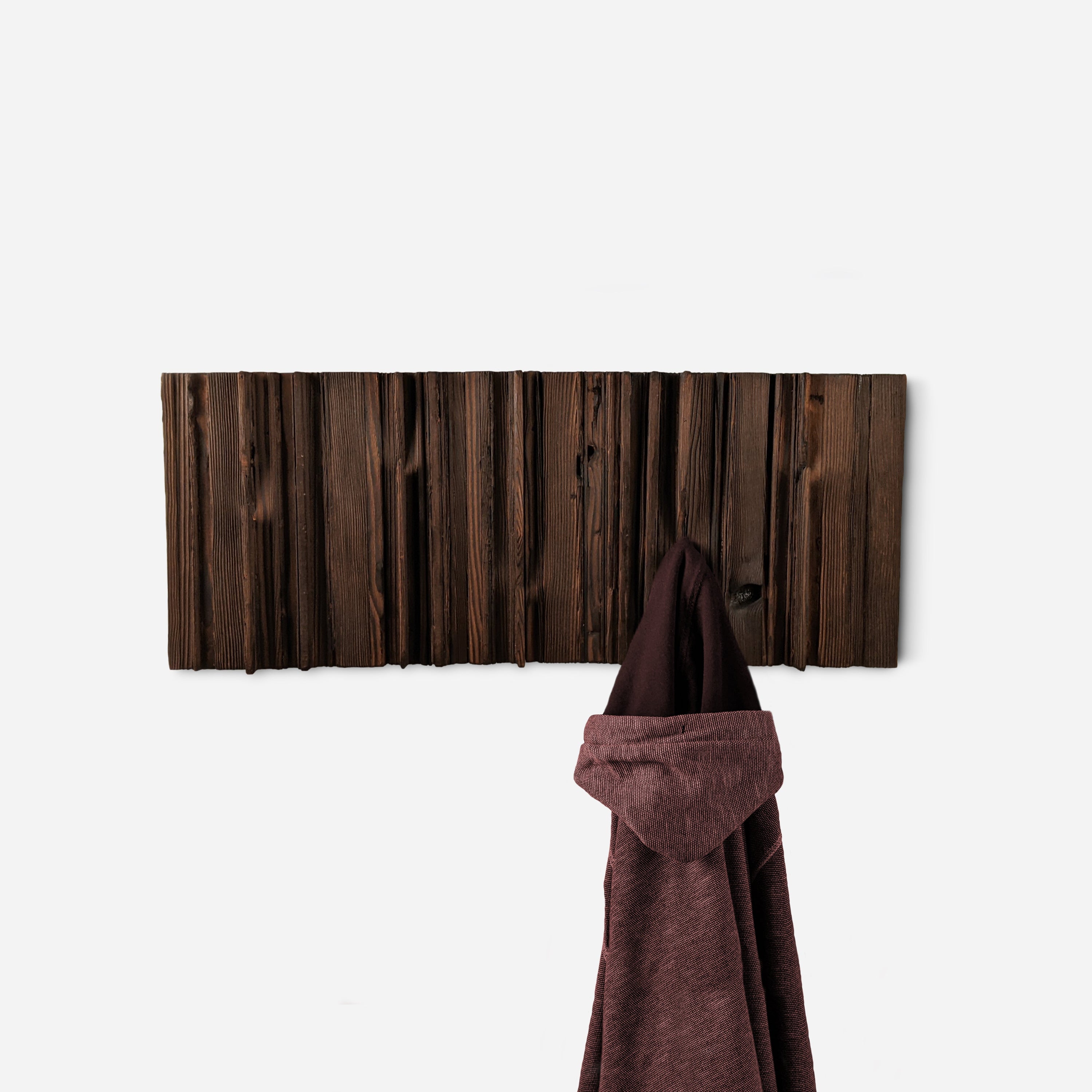 Mr. Hook coat rack featuring unique wood design with brass hooks, showcasing torched black and natural wood finish.