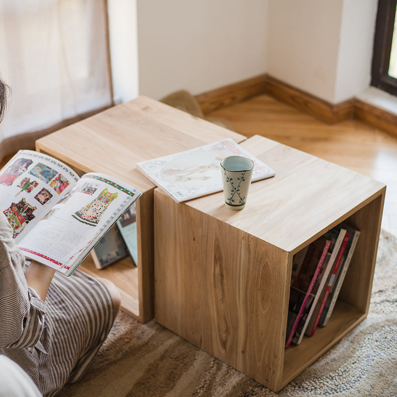 Person reading magazine near side table.