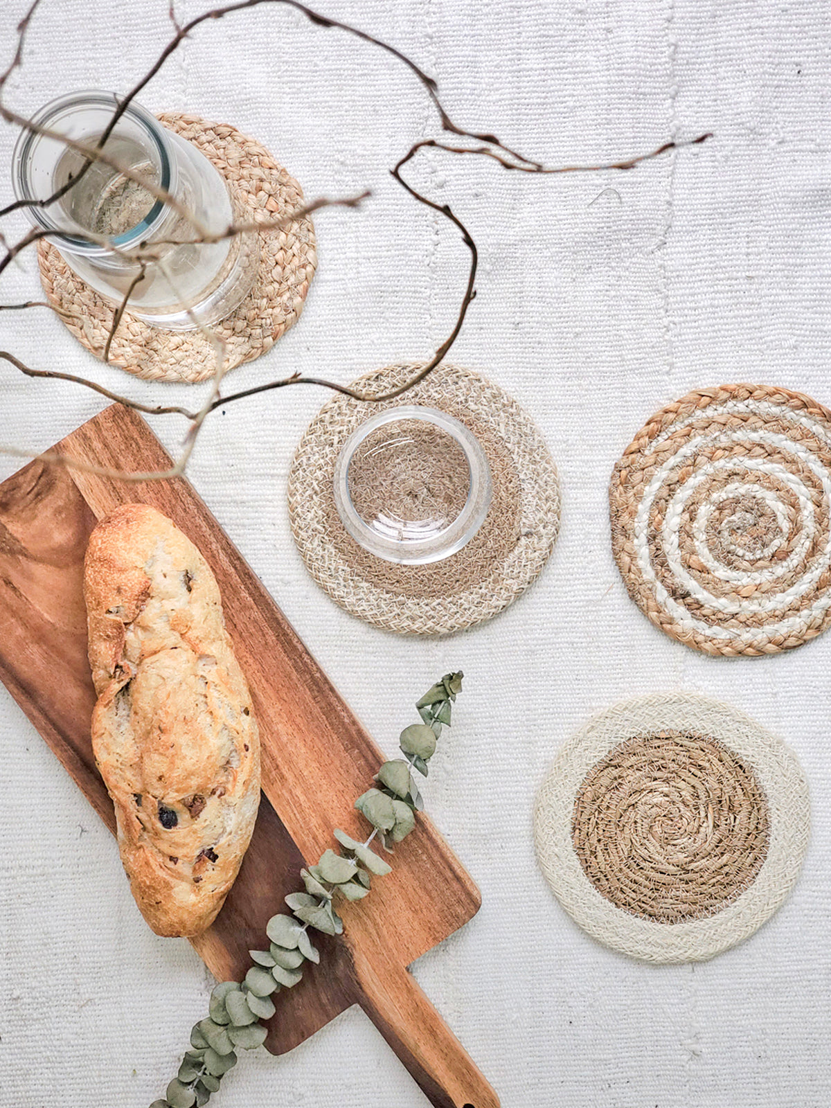 Natural Coaster Trivet Gift Set featuring four handmade coasters made from jute and seagrass, displayed with a green drawstring pouch.