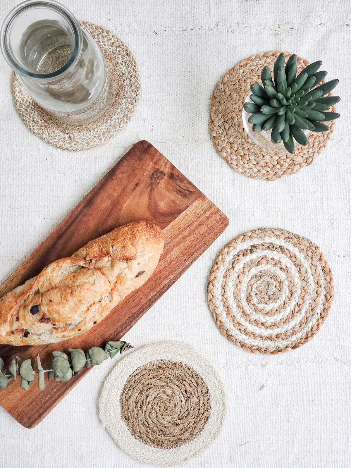 Natural Coaster Trivet Gift Set featuring four handmade coasters made from jute and seagrass, displayed with a green drawstring pouch.