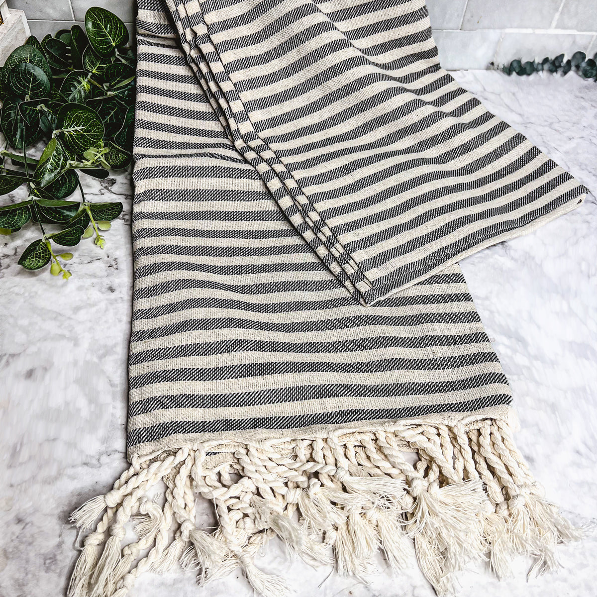 Nautical Towel 180GSM made from 100% Turkish cotton, featuring blue and grey stripes with decorative tassels.