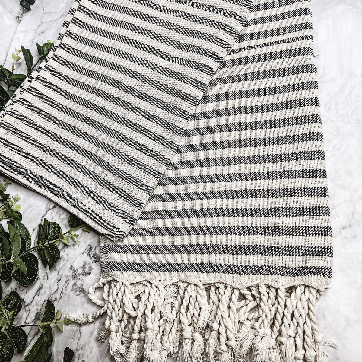 Nautical Towel 180GSM made from 100% Turkish cotton, featuring blue and grey stripes with decorative tassels.