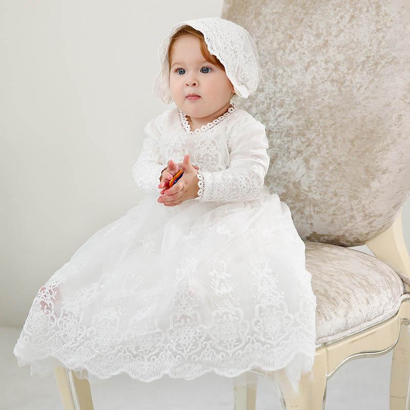 New lace baby girl baptism gown in white, featuring a ball gown silhouette with lace decoration and available in long sleeve and sleeveless options.