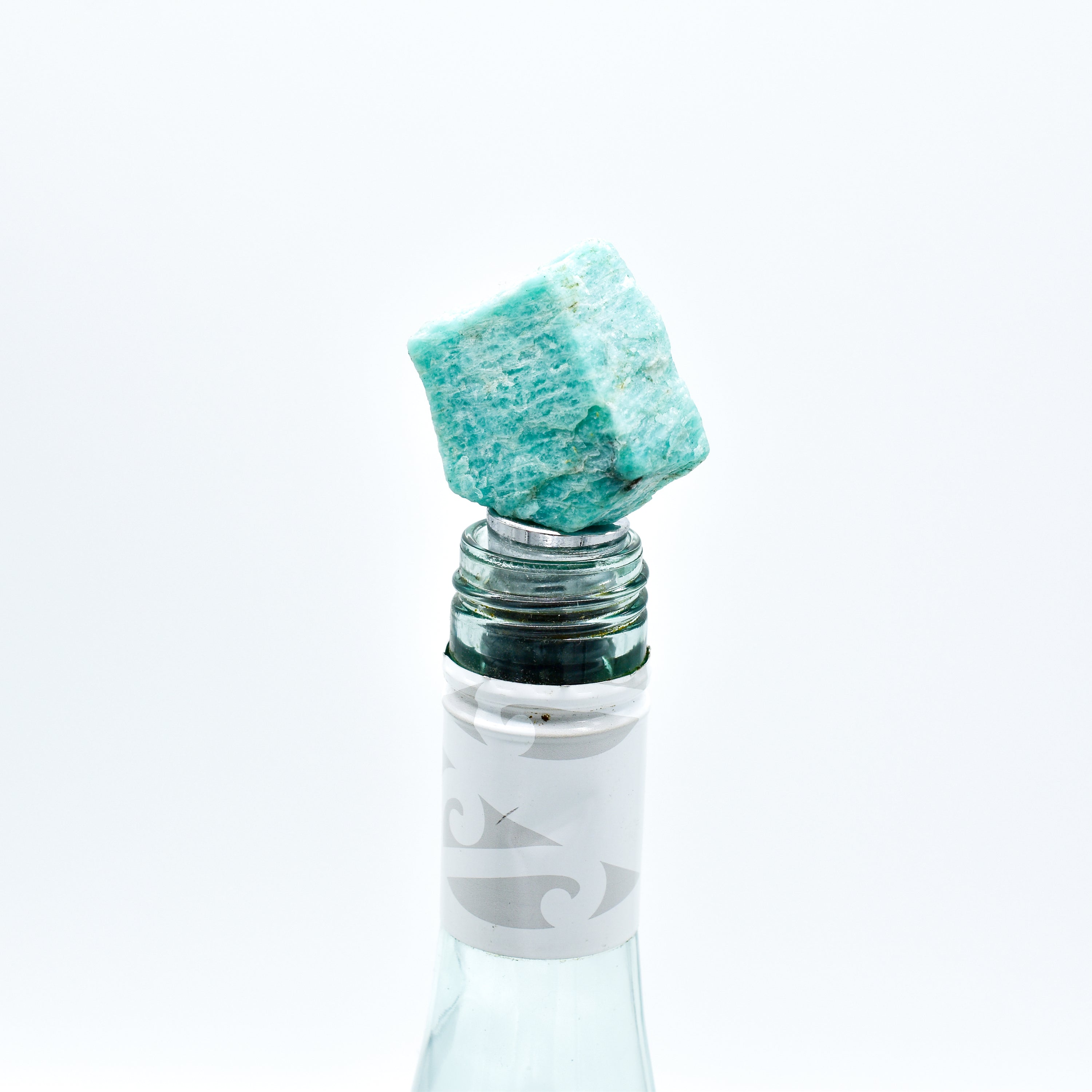 A collection of unique natural stone wine bottle stoppers made from Rose Quartz, Amazonite, Apatite, Amethyst, and Labradorite with stainless steel bases.