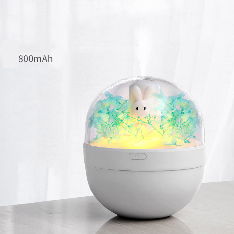 A cute rabbit-shaped humidifier in white and pink, designed for desktop use, showcasing its compact size and USB charging feature.