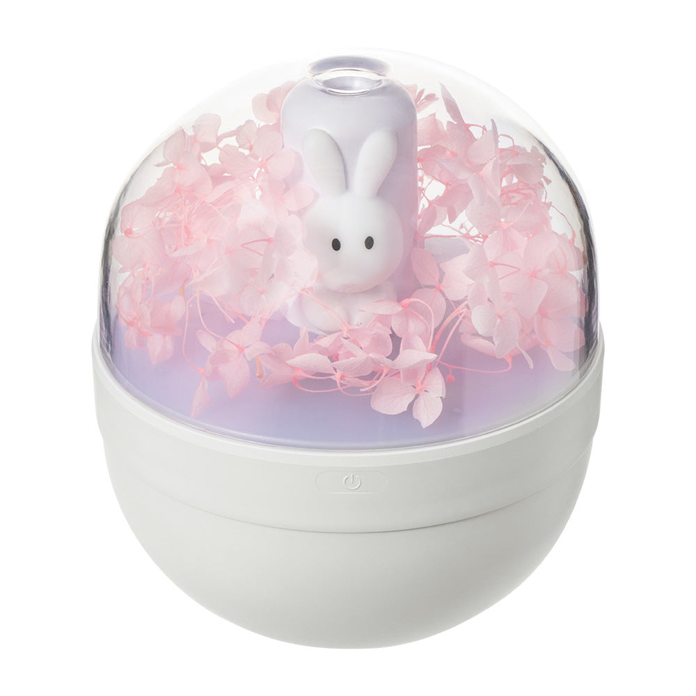 A cute rabbit-shaped humidifier in white and pink, designed for desktop use, showcasing its compact size and USB charging feature.