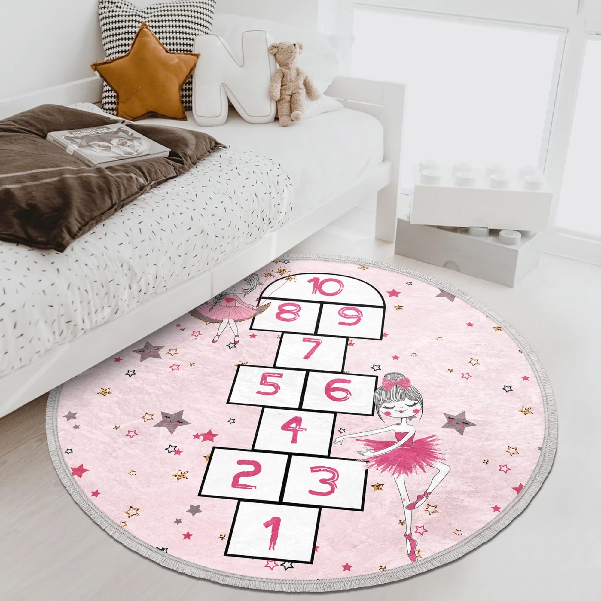 A vibrant pink circle rug featuring playful numbers, perfect for a child's room or nursery, showcasing its soft texture and non-slip backing.