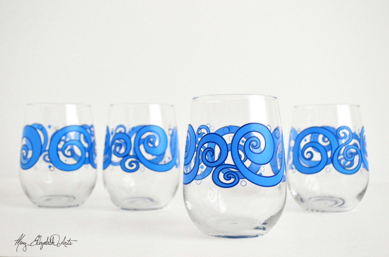 Ocean Waves Stemless Wine Glasses featuring a beautiful ocean wave design, perfect for enjoying beverages.