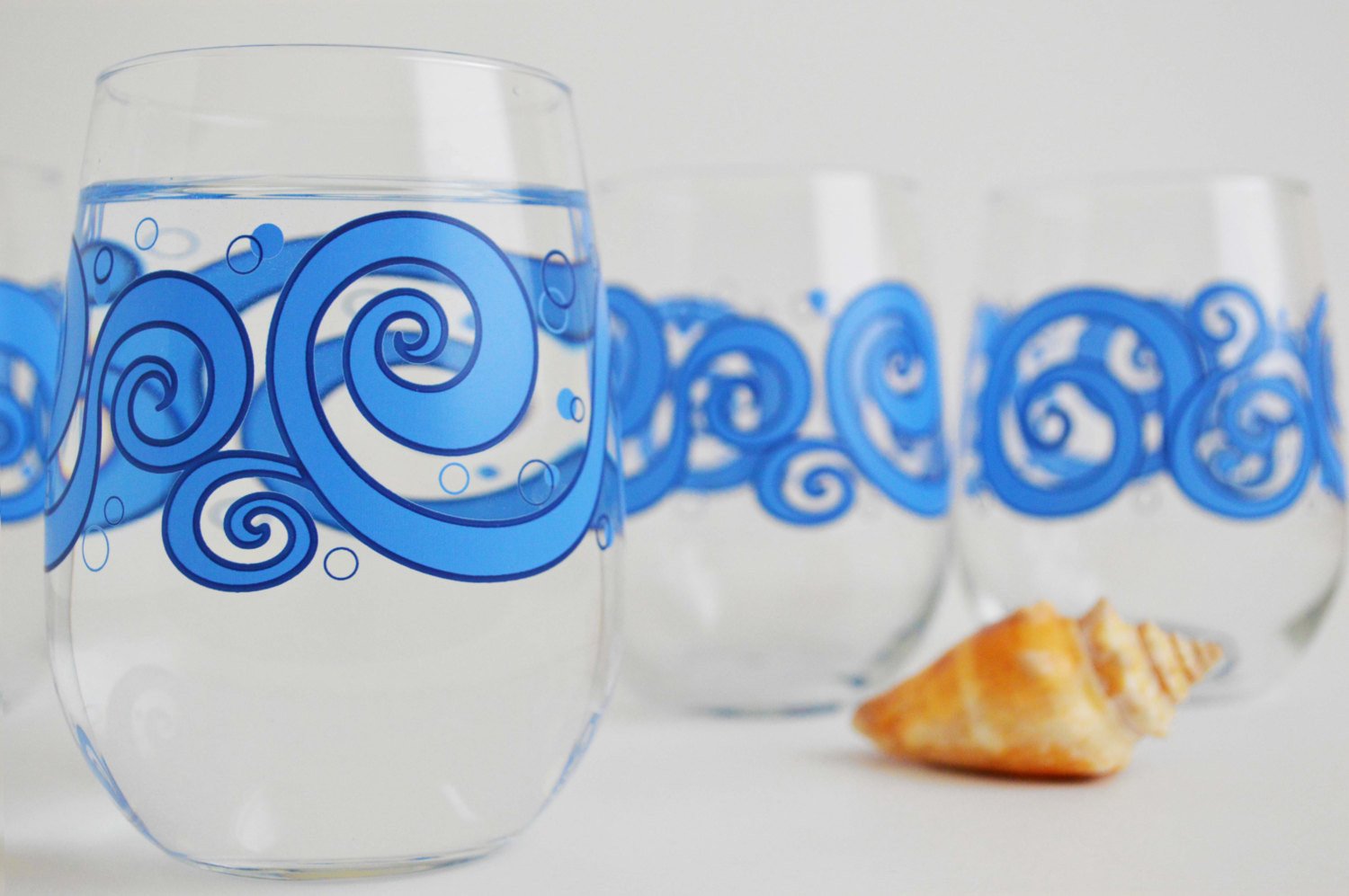 Ocean Waves Stemless Wine Glasses featuring a beautiful ocean wave design, perfect for enjoying beverages.