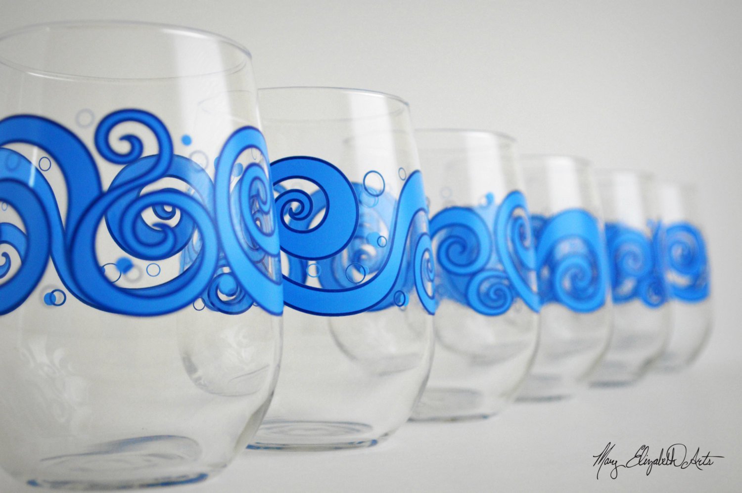 Ocean Waves Stemless Wine Glasses featuring a beautiful ocean wave design, perfect for enjoying beverages.