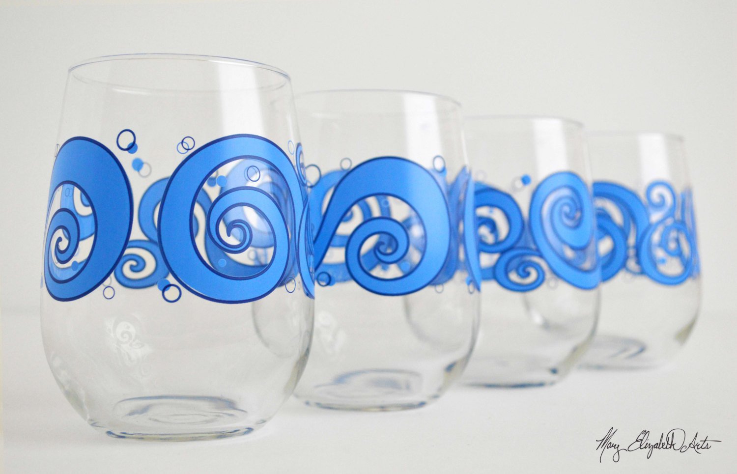 Ocean Waves Stemless Wine Glasses featuring a beautiful ocean wave design, perfect for enjoying beverages.