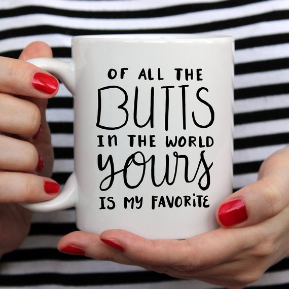 A humorous coffee mug featuring the phrase 'Of All The Butts In The World, Yours Is My Favorite', crafted from high-grade ceramic, ideal for coffee lovers.