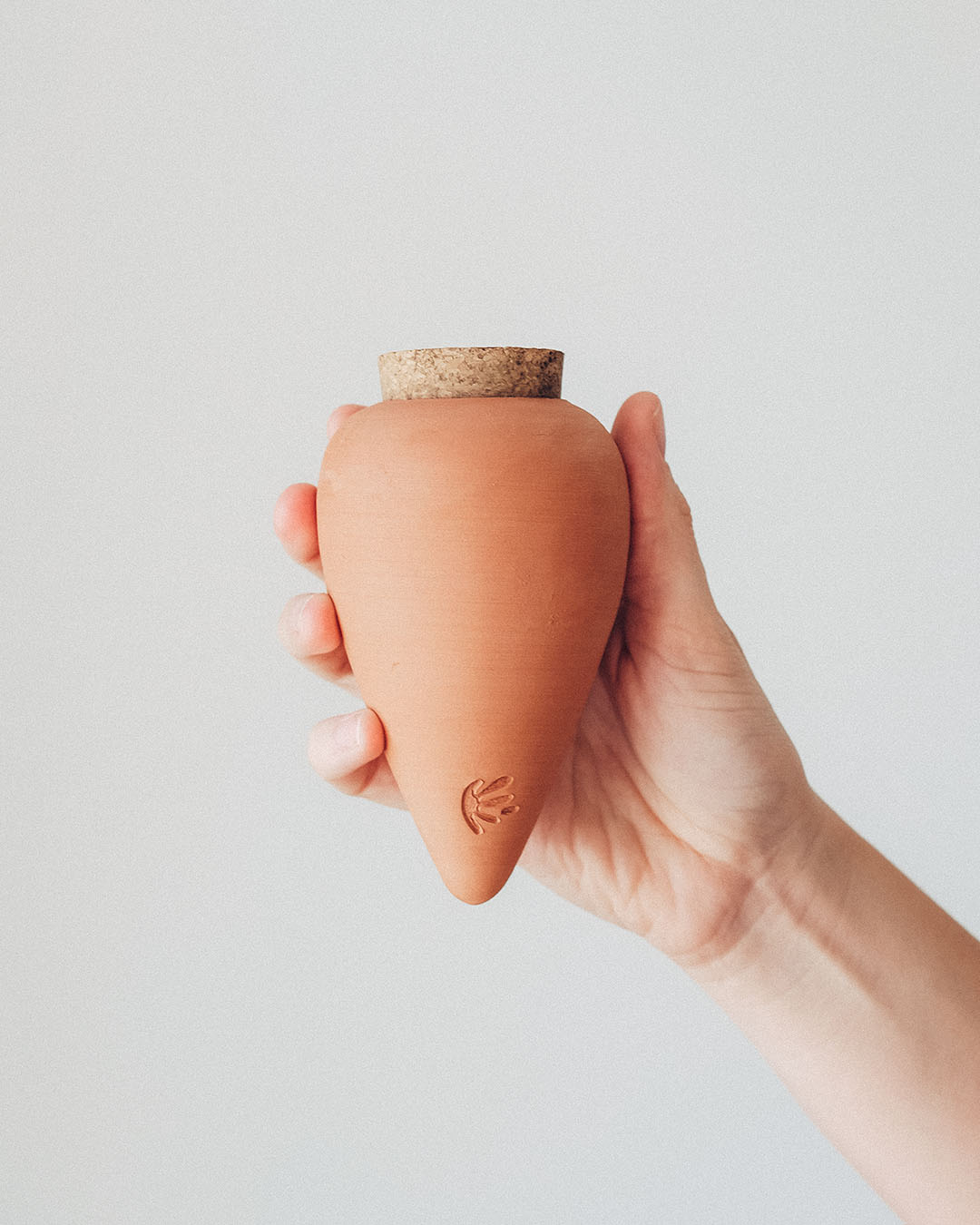 Olla de Auto Riego Terracota, un recipiente poroso ideal para el riego eficiente de plantas, enterrado en una maceta con agua.