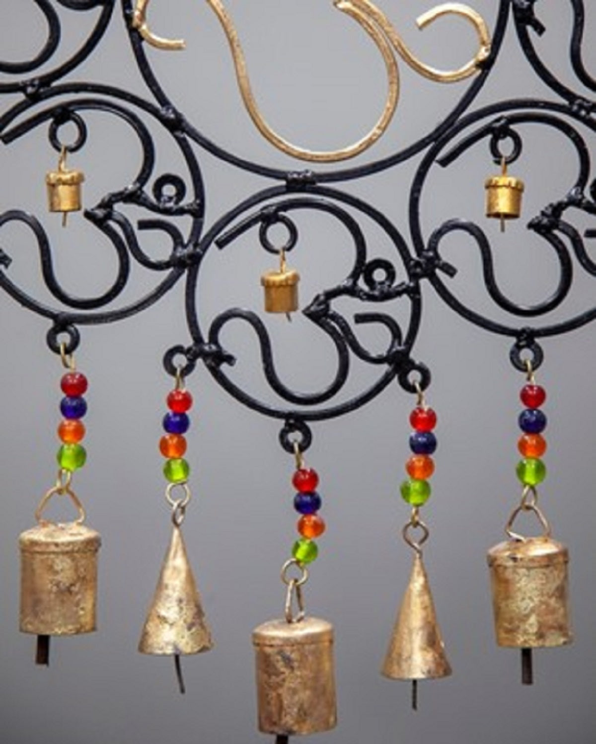 A colorful OM Brass Bells wall hanging featuring vibrant glass beads, showcasing intricate craftsmanship and a positive vibe.