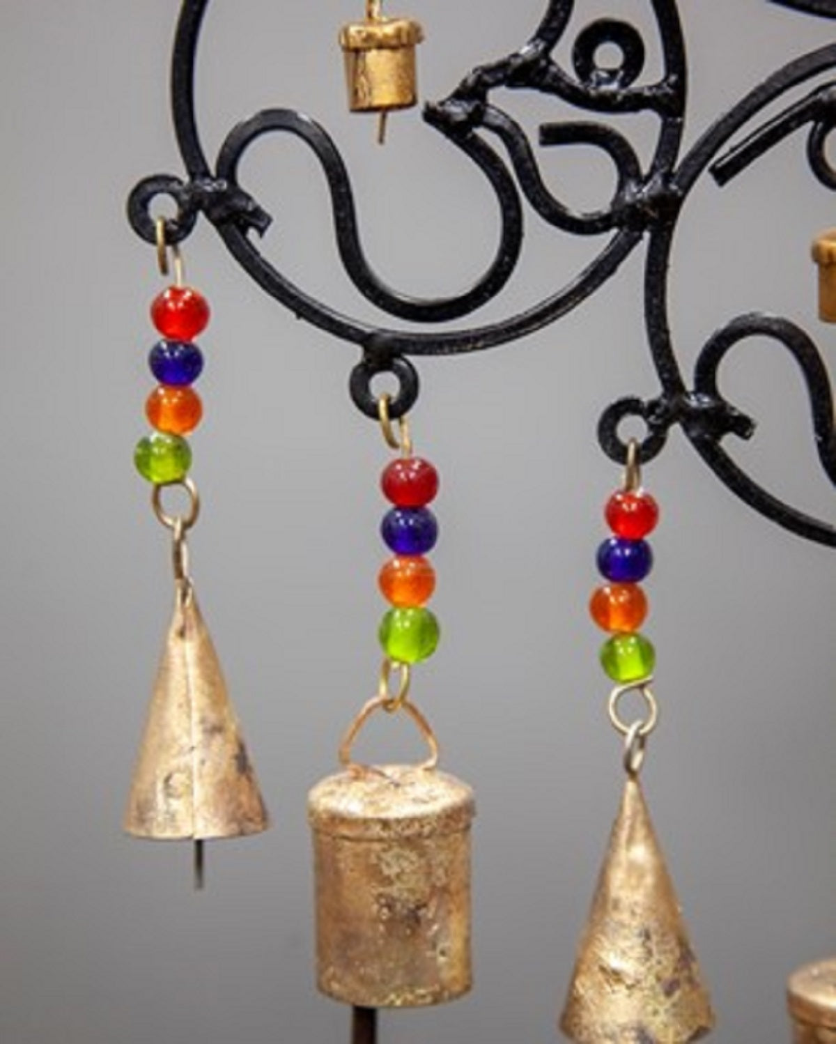 A colorful OM Brass Bells wall hanging featuring vibrant glass beads, showcasing intricate craftsmanship and a positive vibe.