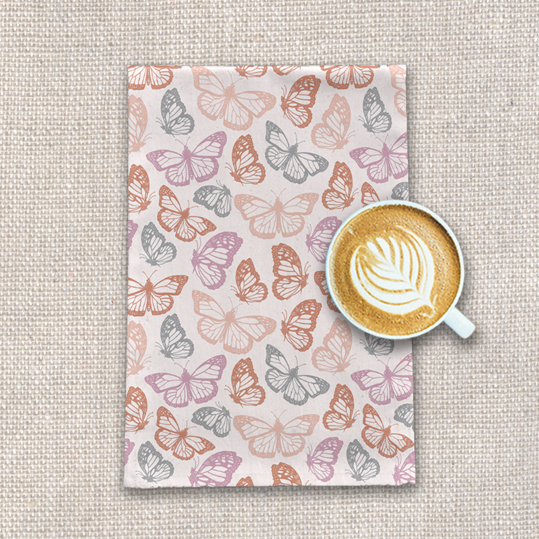 Orange and pink butterfly tea towel made of cotton twill, featuring a vibrant design and hemmed edges, perfect for kitchen use.