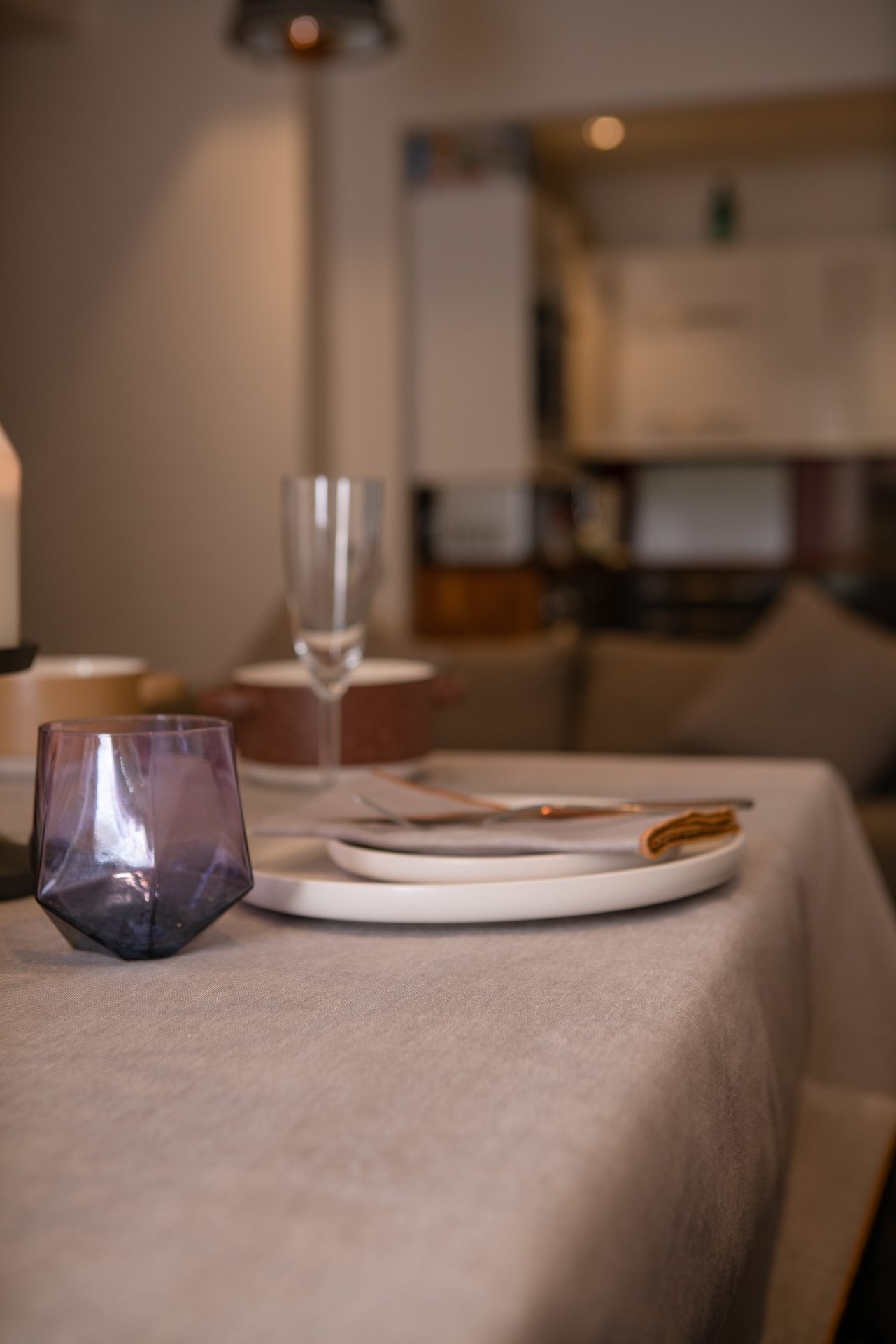 A luxurious organic cotton table cloth with a chambray weave, featuring a baby overlook border, elegantly draped over a dining table.