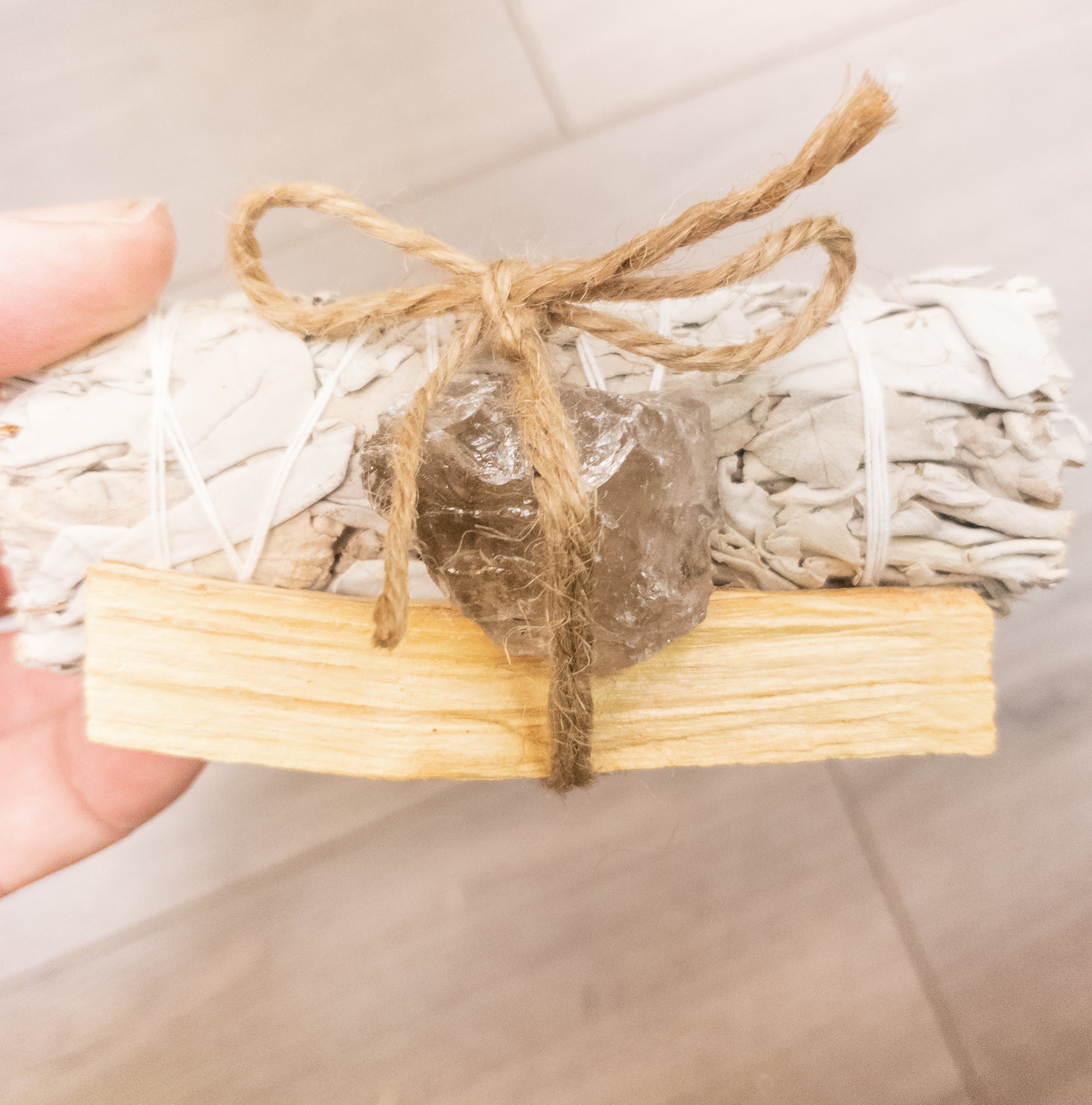 Palo Santo and Sage smudging bundle with assorted crystals, showcasing natural wood and vibrant crystal colors.