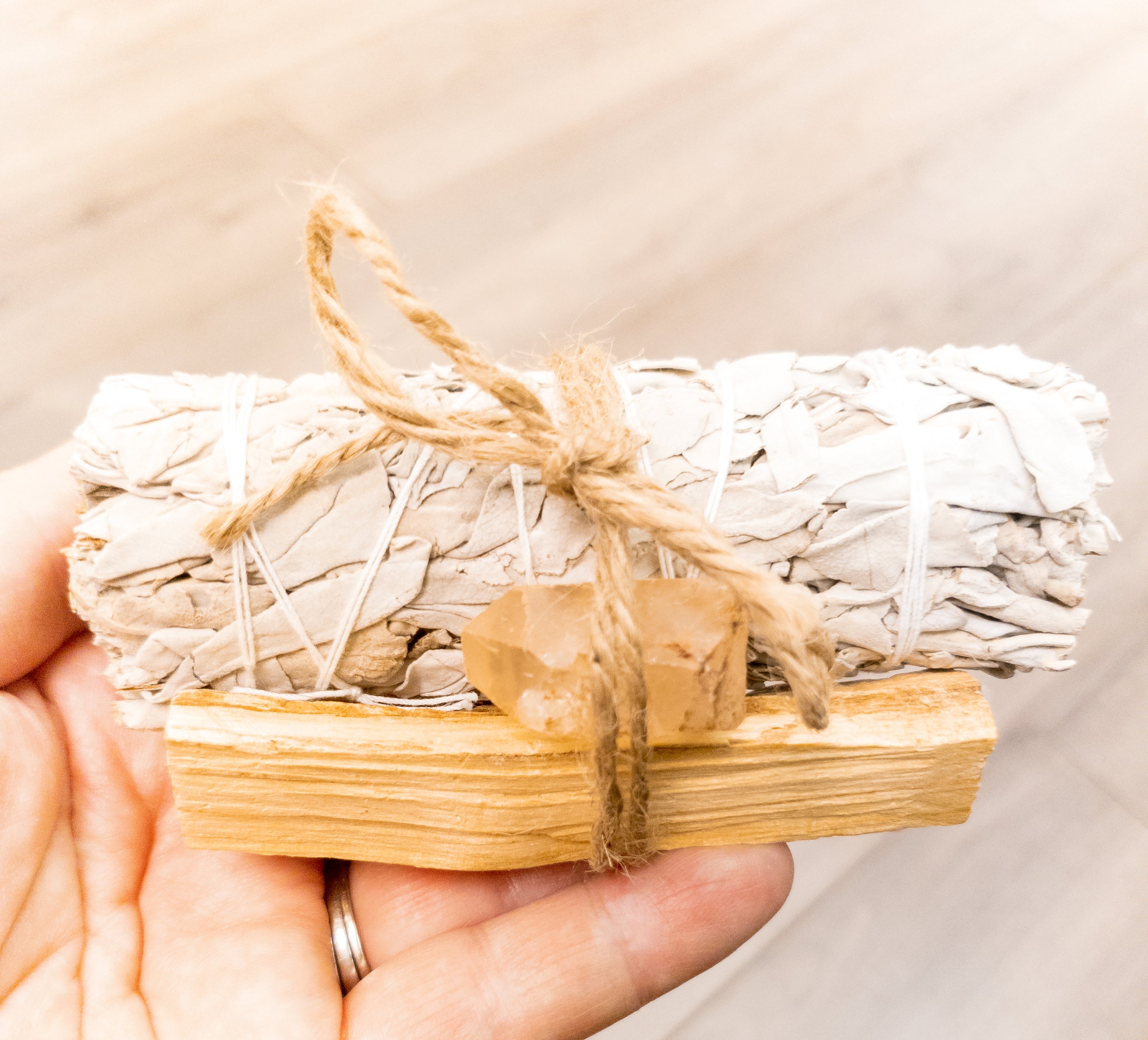 Palo Santo and Sage smudging bundle with assorted crystals, showcasing natural wood and vibrant crystal colors.