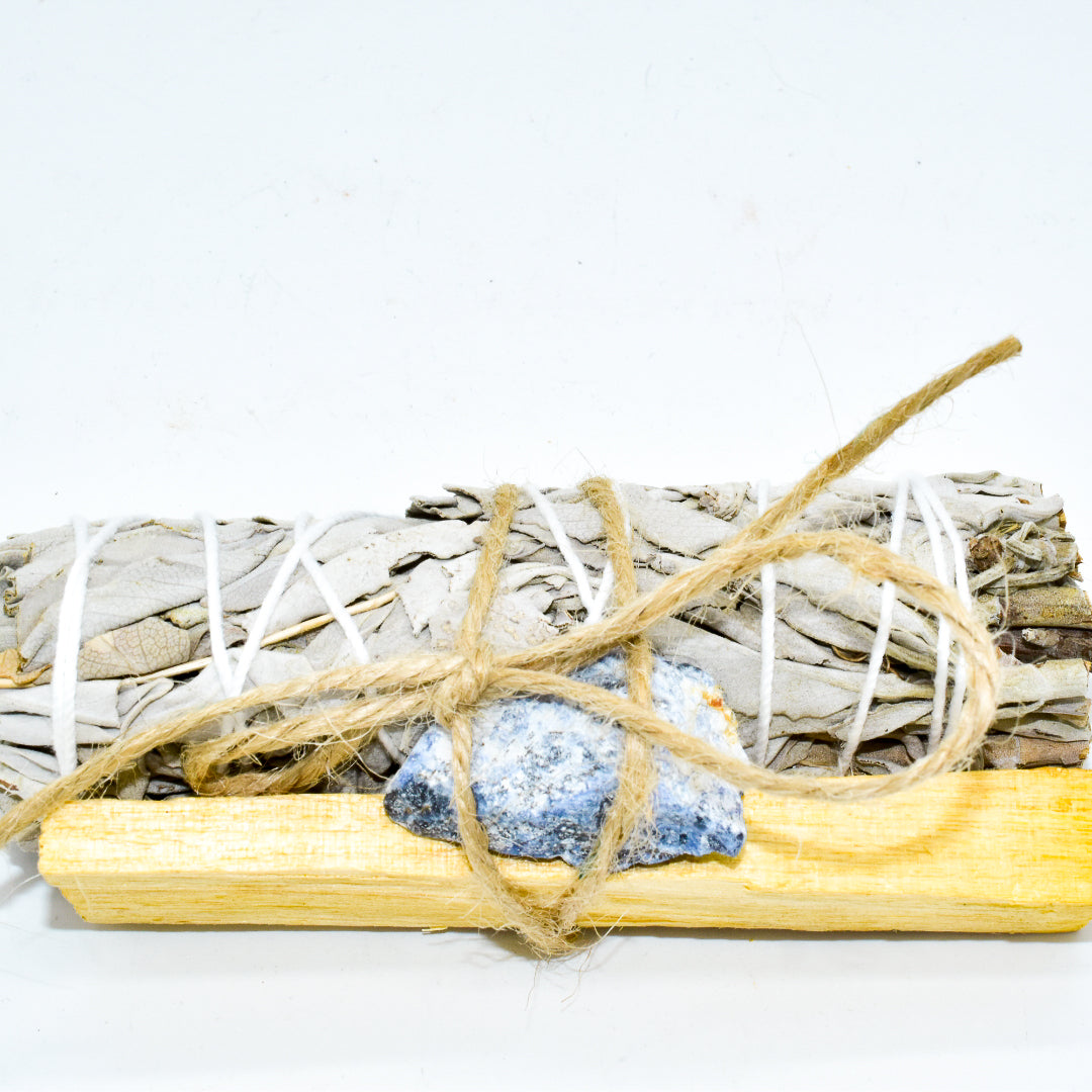 Palo Santo and Sage smudging bundle with assorted crystals, showcasing natural wood and vibrant crystal colors.