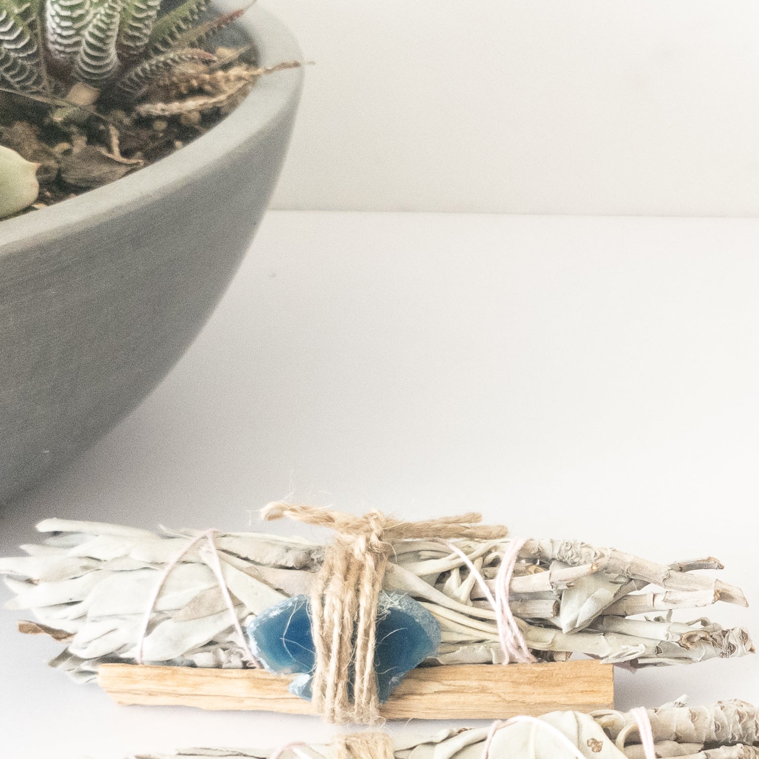 Palo Santo and Sage smudging bundle with assorted crystals, showcasing natural wood and vibrant crystal colors.