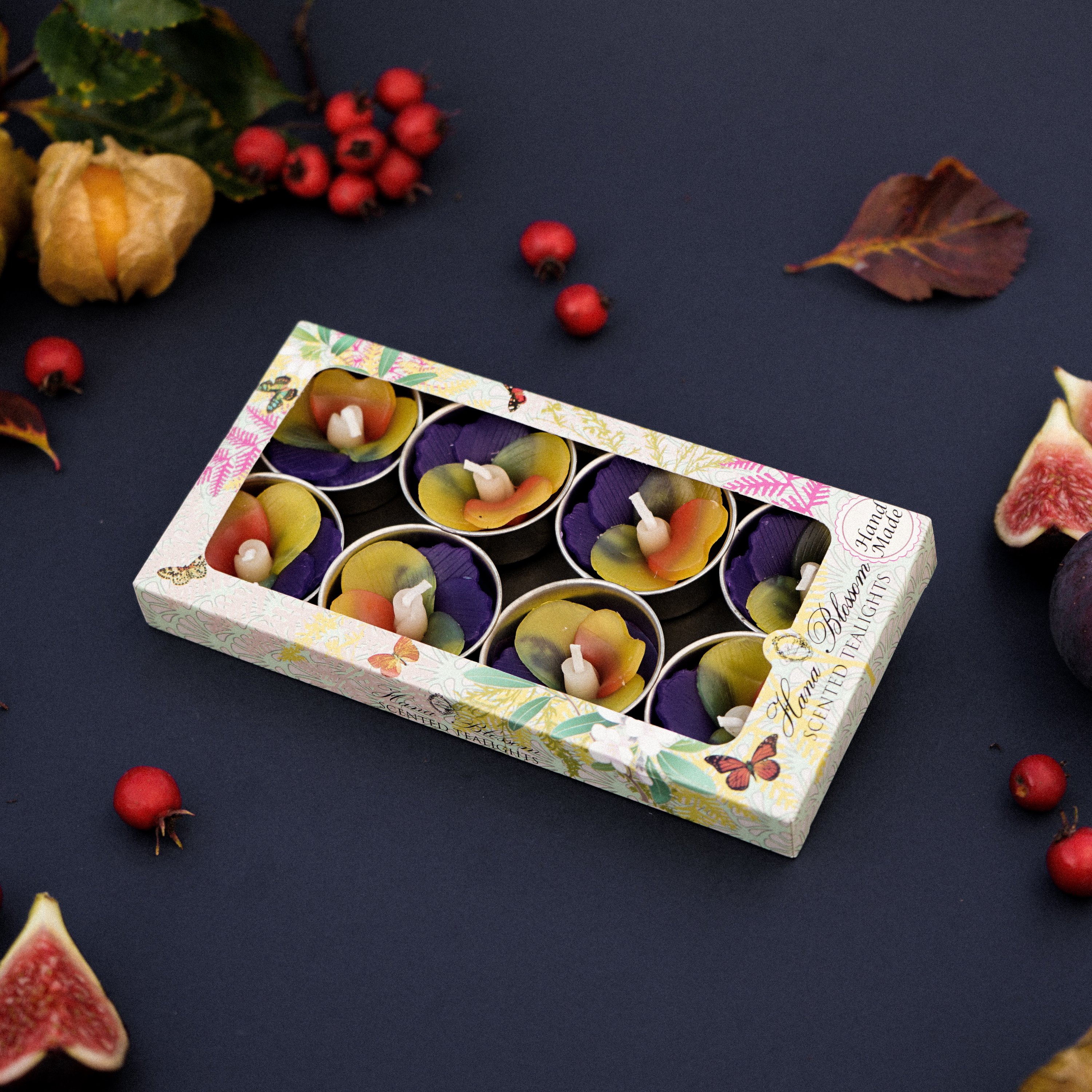 A set of handmade Pansy Scented Tealights in purple and yellow, beautifully packaged in a botanic garden printed box.