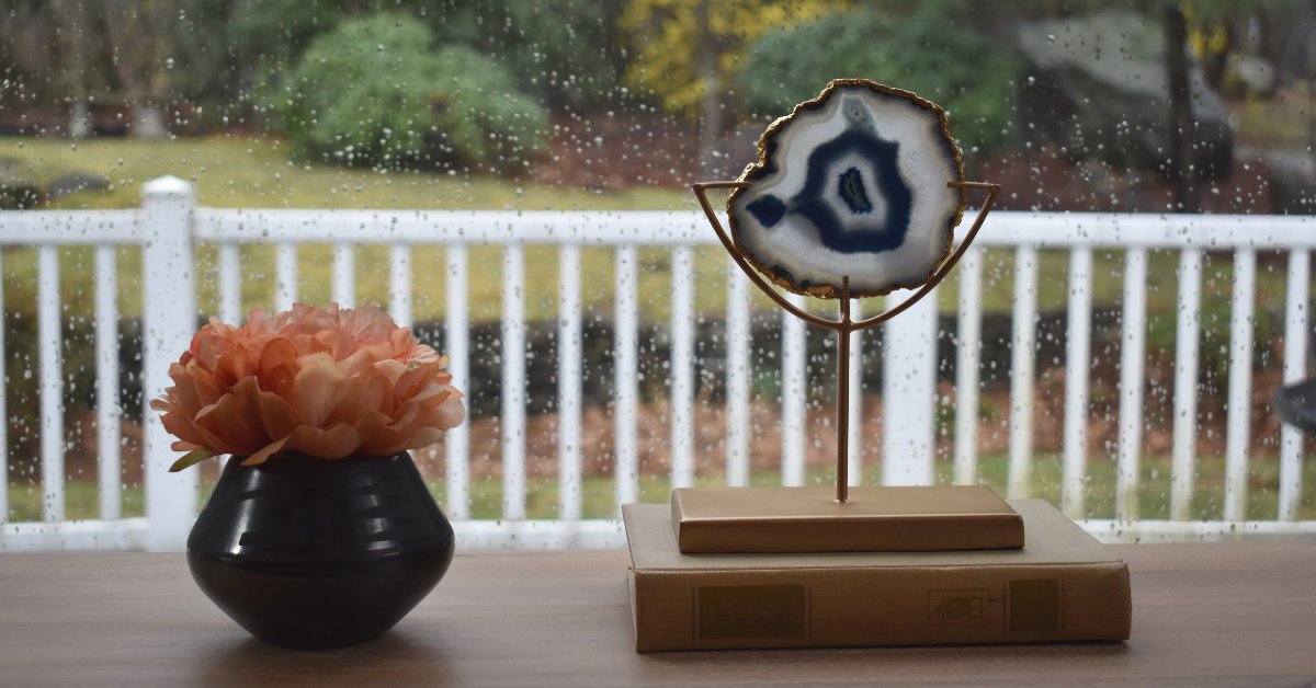 A beautiful pastel blue agate slice displayed on a decorative gold stand, showcasing its vibrant colors and unique patterns.