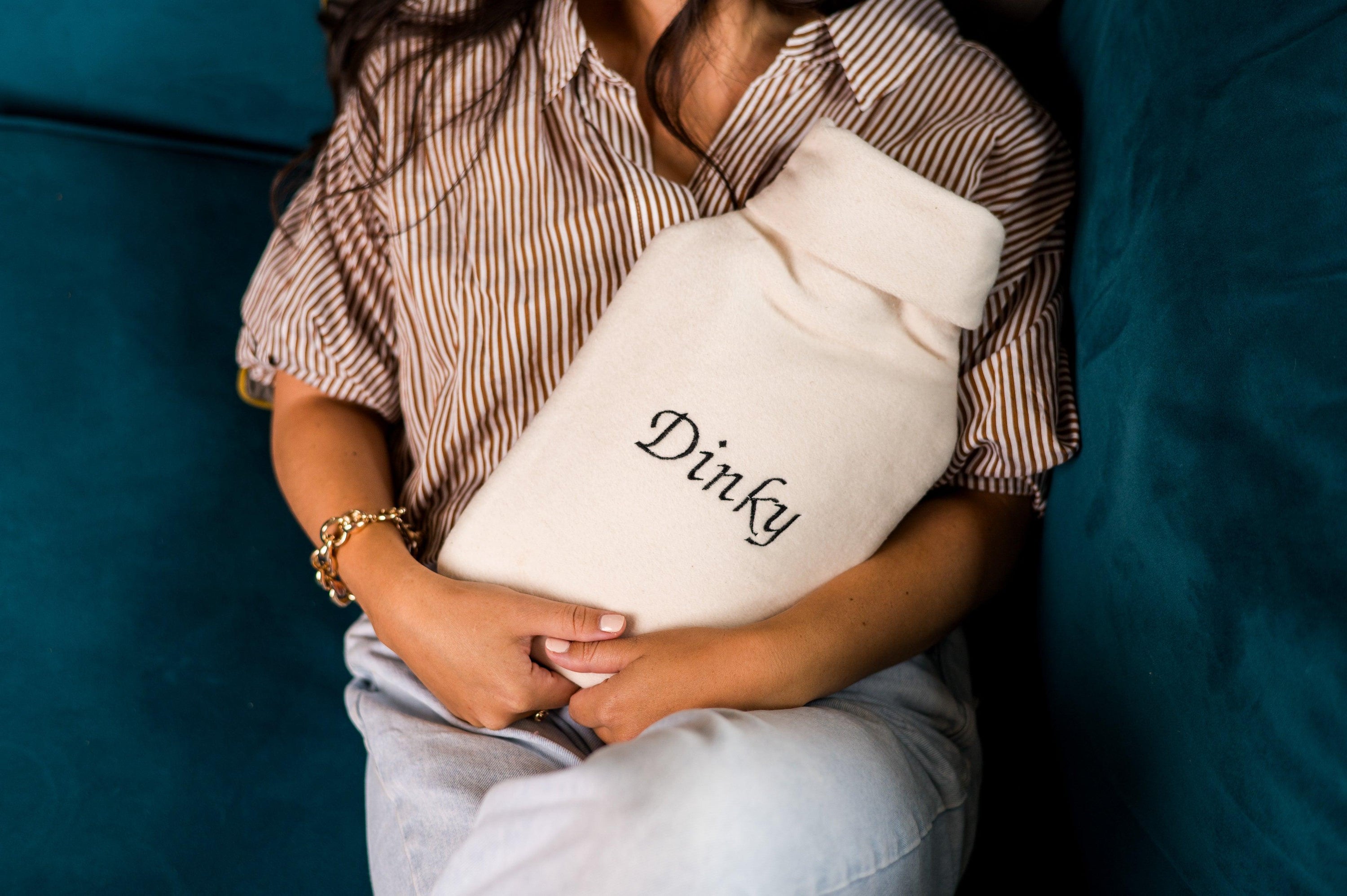 A cozy personalised hot water bottle cover made from bamboo and organic cotton, featuring embroidered names and initials, perfect for warmth and comfort.