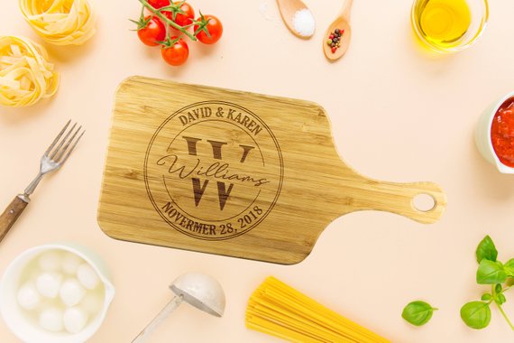 A personalized bamboo cutting board with laser-etched design, showcasing its dual-purpose functionality for food preparation and display.