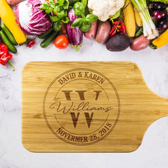 A personalized bamboo cutting board with laser-etched design, showcasing its dual-purpose functionality for food preparation and display.