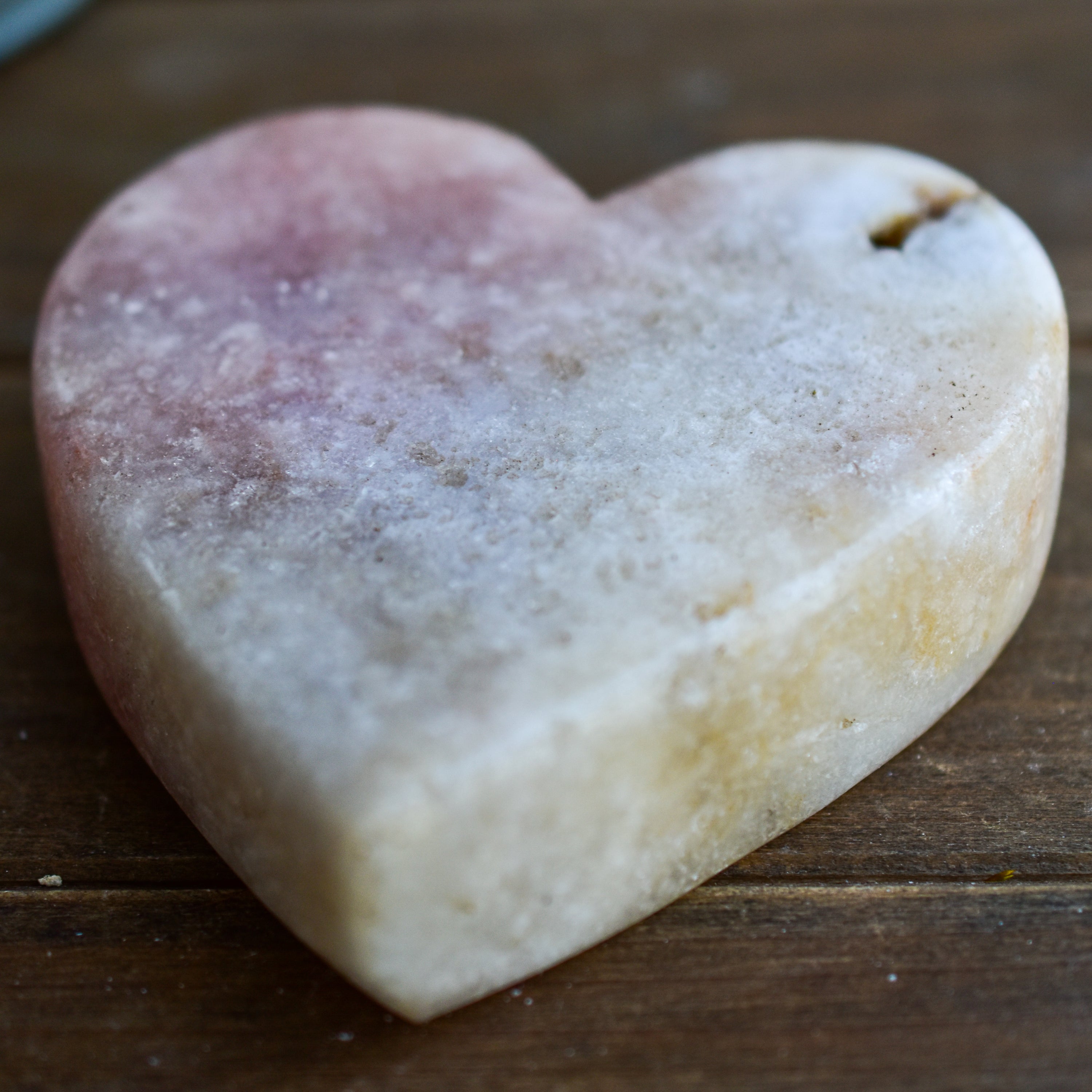 A collection of hand-cut Pink Amethyst hearts showcasing unique colors and sizes, polished to perfection by artisans in Brazil.