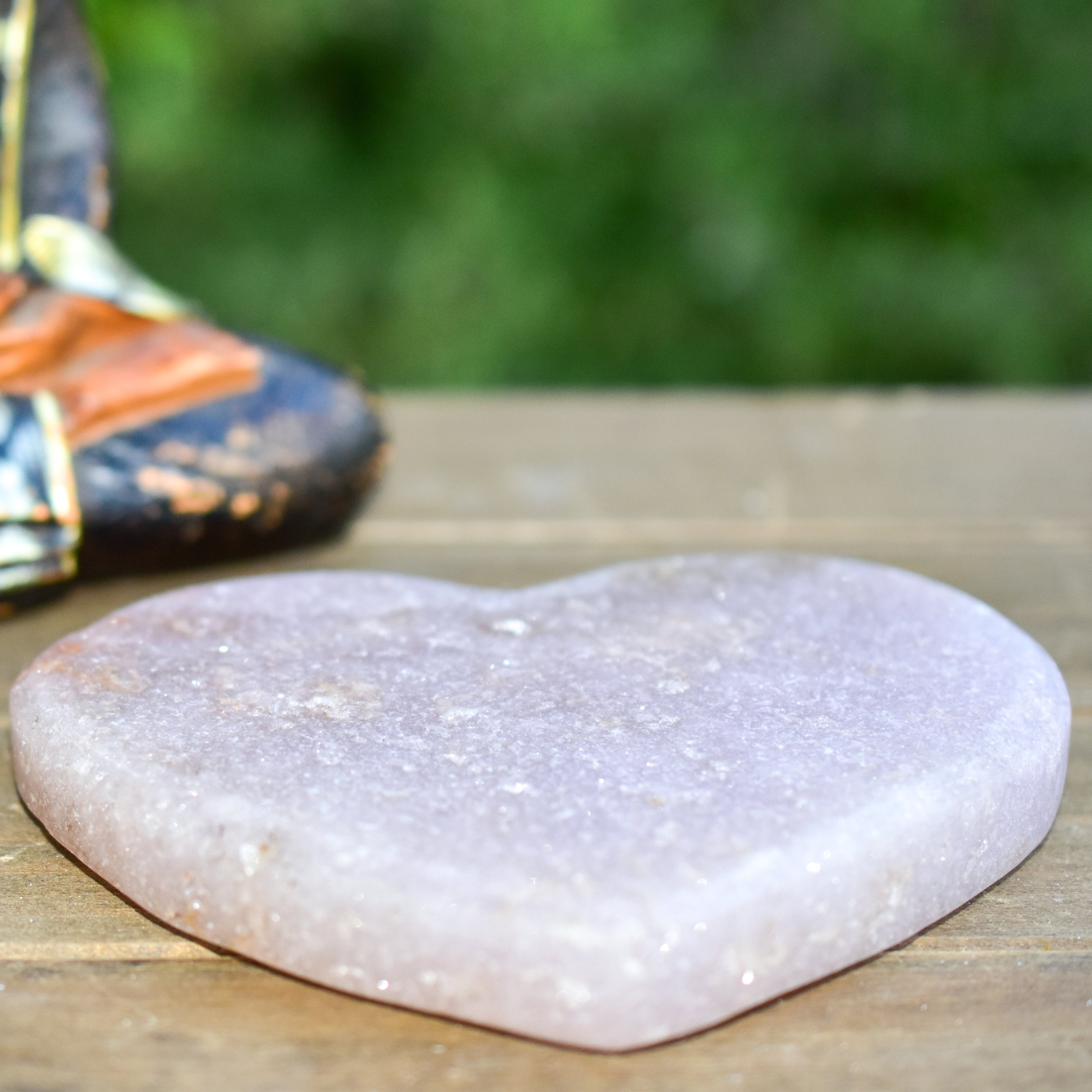 A collection of hand-cut Pink Amethyst hearts showcasing unique colors and sizes, polished to perfection by artisans in Brazil.