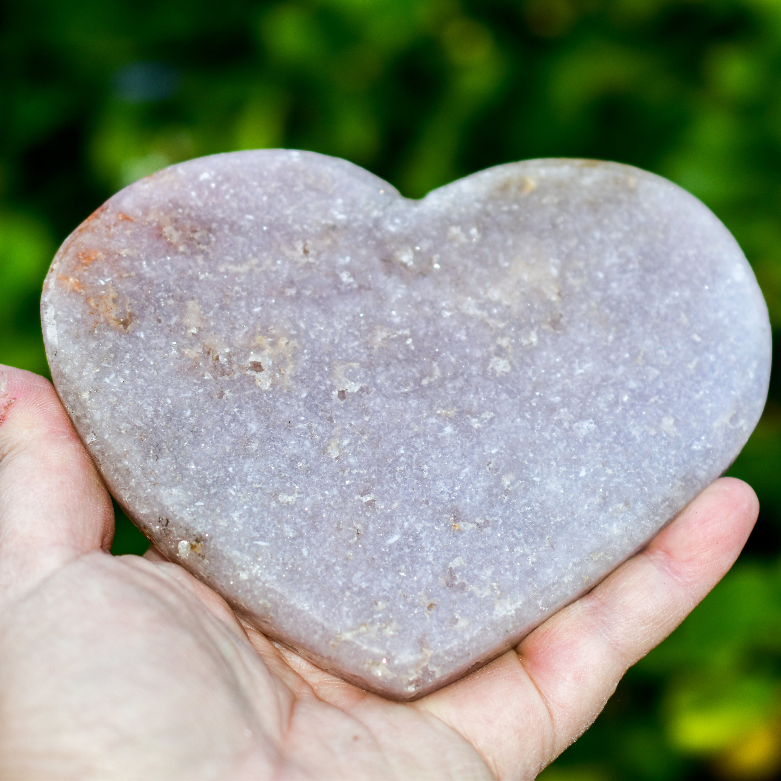 A collection of hand-cut Pink Amethyst hearts showcasing unique colors and sizes, polished to perfection by artisans in Brazil.