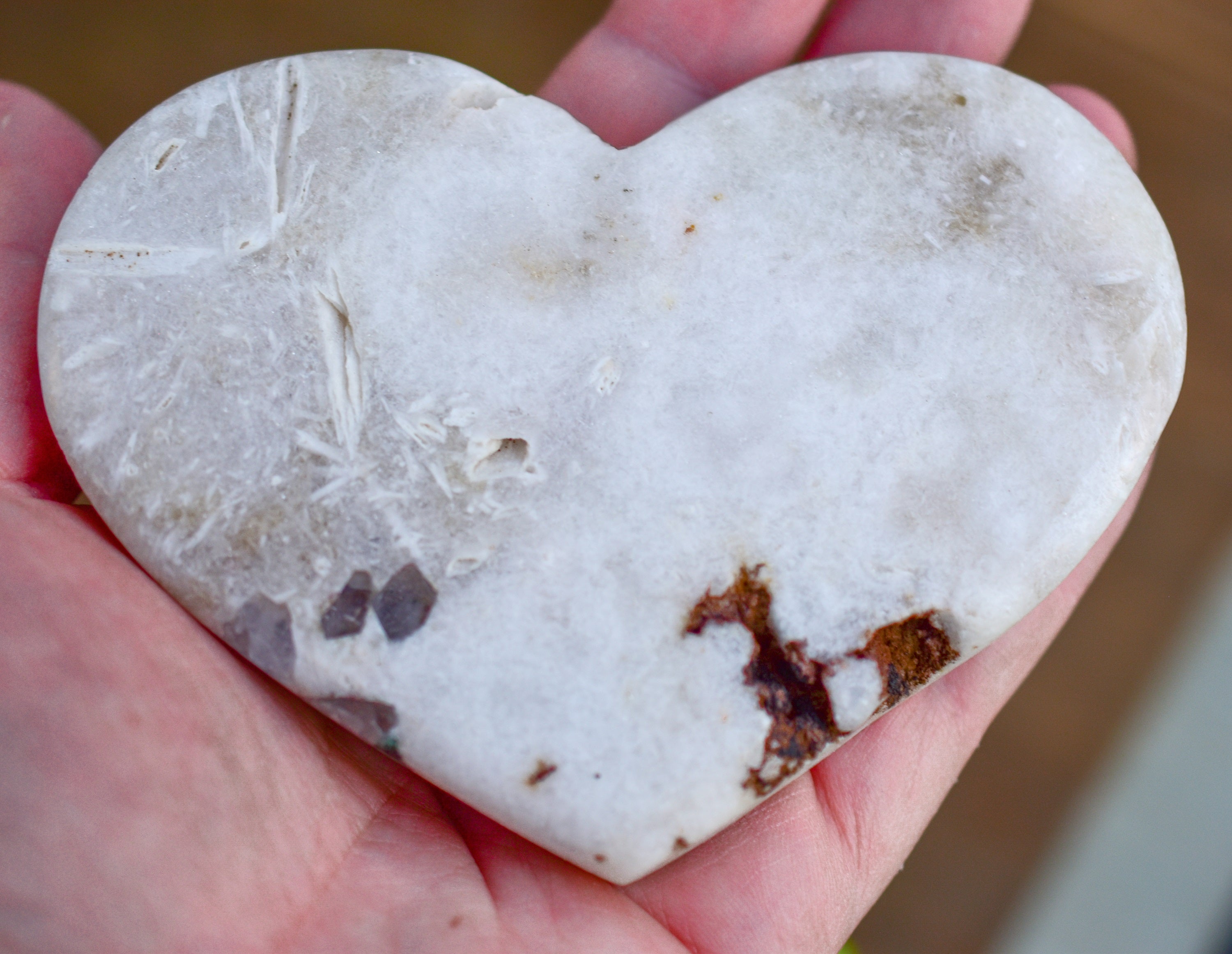 A collection of hand-cut Pink Amethyst hearts showcasing unique colors and sizes, polished to perfection by artisans in Brazil.