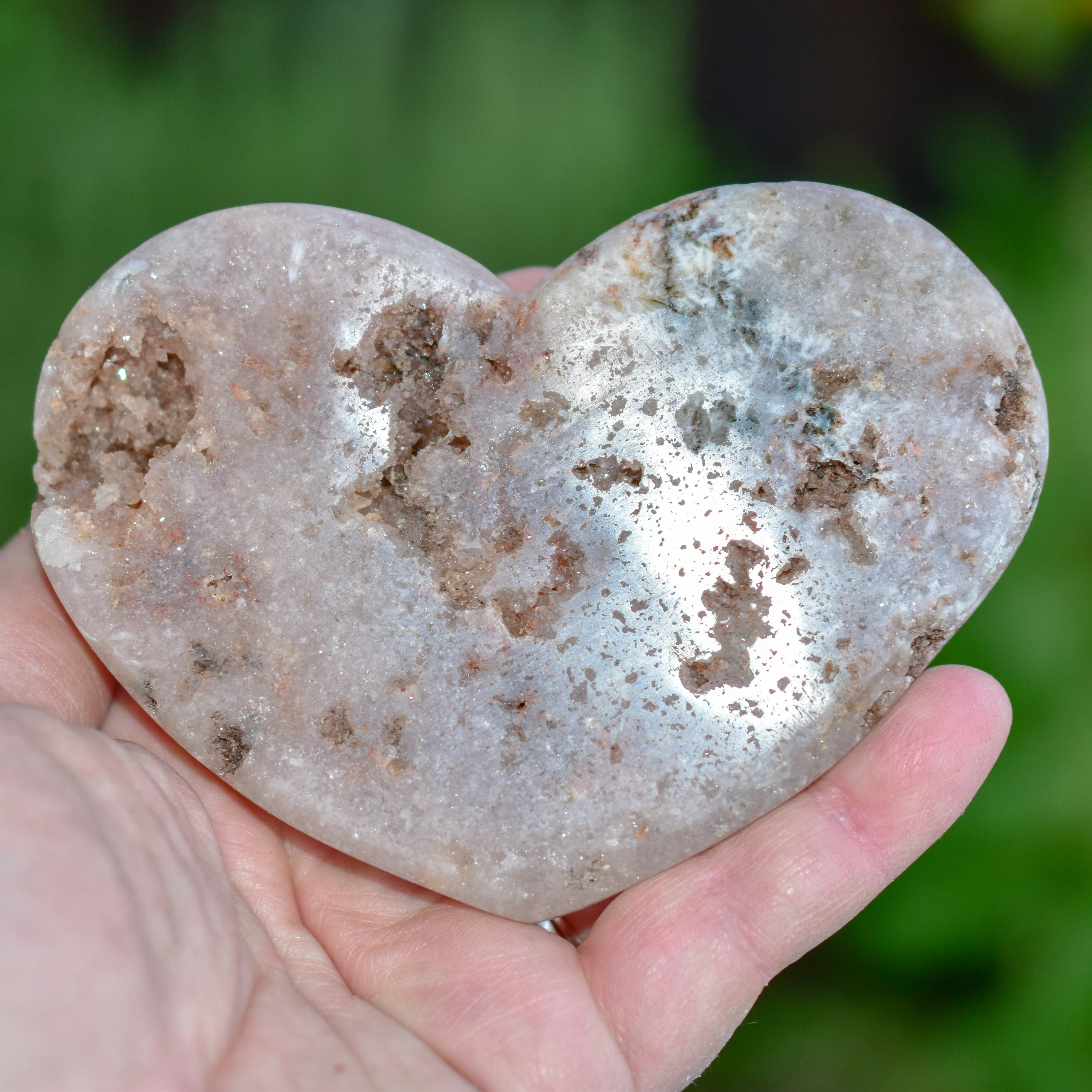 A collection of hand-cut Pink Amethyst hearts showcasing unique colors and sizes, polished to perfection by artisans in Brazil.