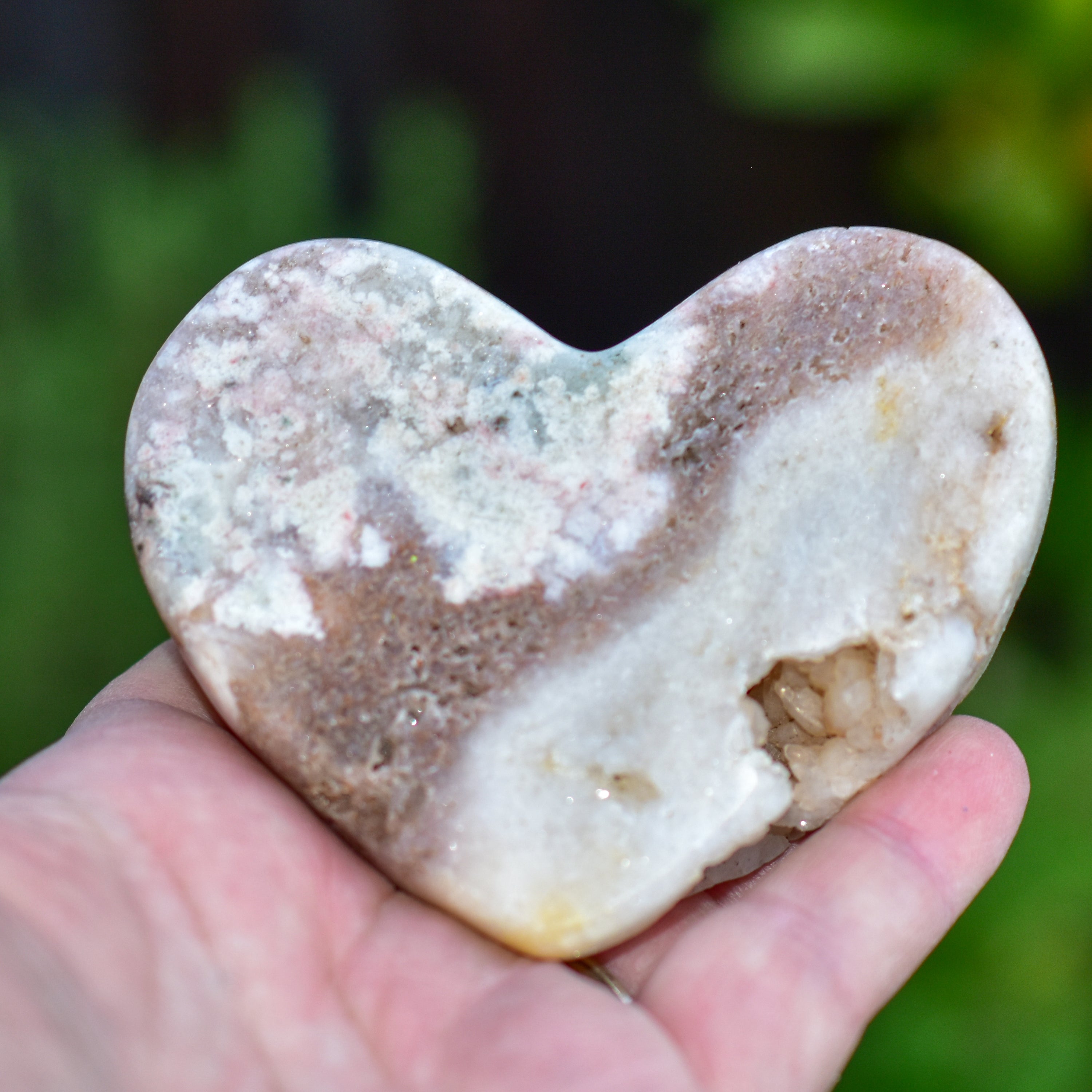 A collection of hand-cut Pink Amethyst hearts showcasing unique colors and sizes, polished to perfection by artisans in Brazil.