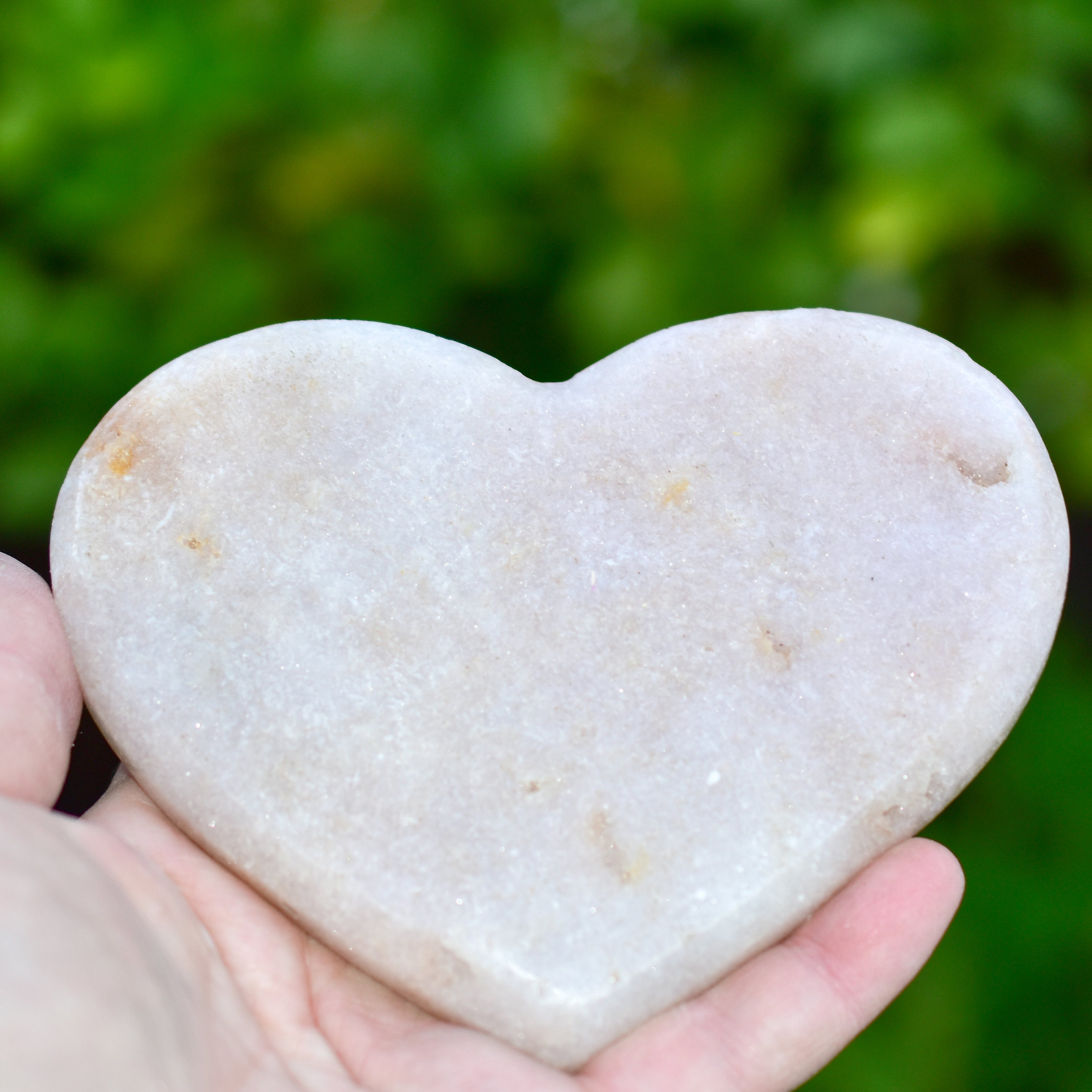 A collection of hand-cut Pink Amethyst hearts showcasing unique colors and sizes, polished to perfection by artisans in Brazil.