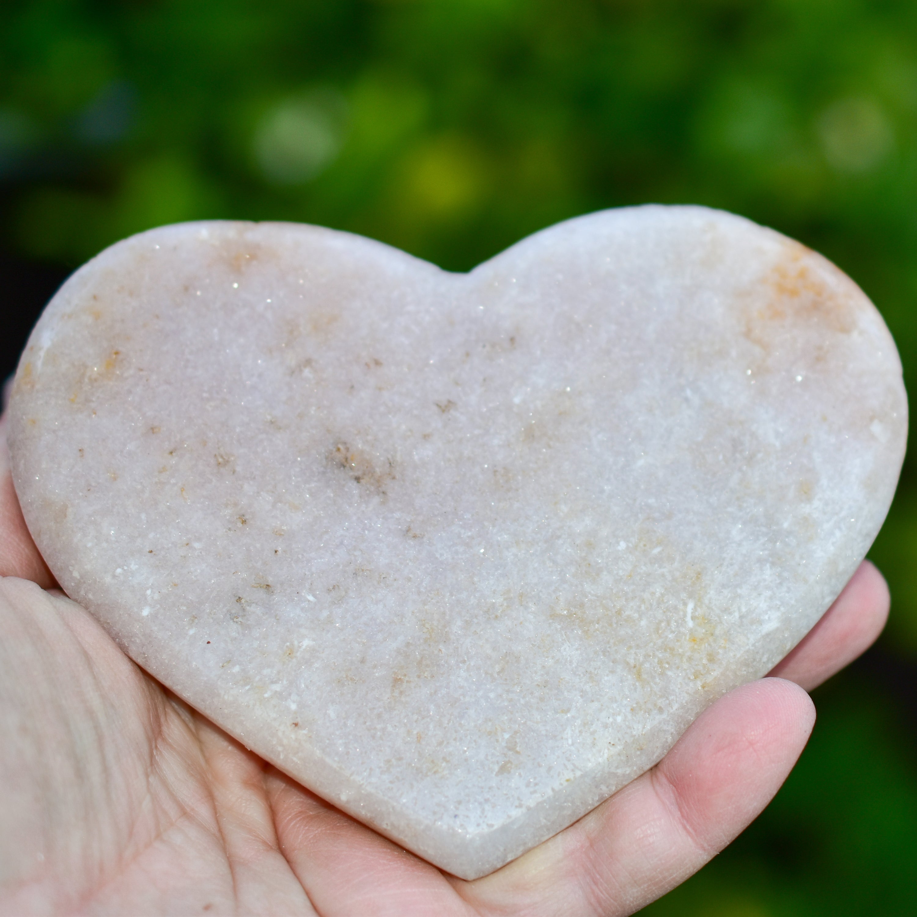 A collection of hand-cut Pink Amethyst hearts showcasing unique colors and sizes, polished to perfection by artisans in Brazil.