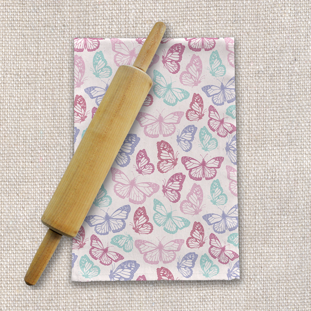 A vibrant pink tea towel featuring a butterfly design, made from durable cotton twill, perfect for kitchen use.