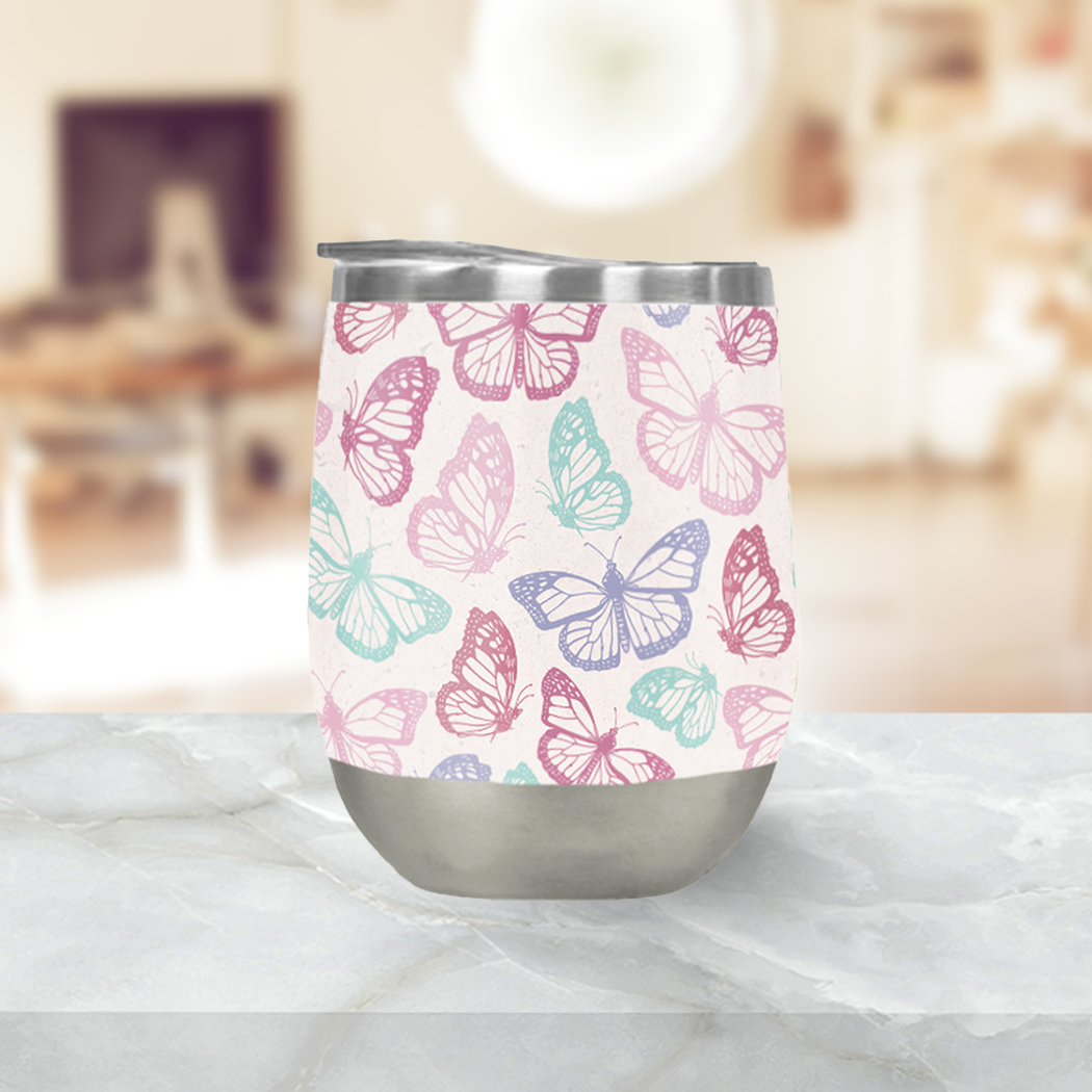 A stylish pink butterfly wine tumbler made of stainless steel, featuring a double-wall design for insulation and a plastic lid.